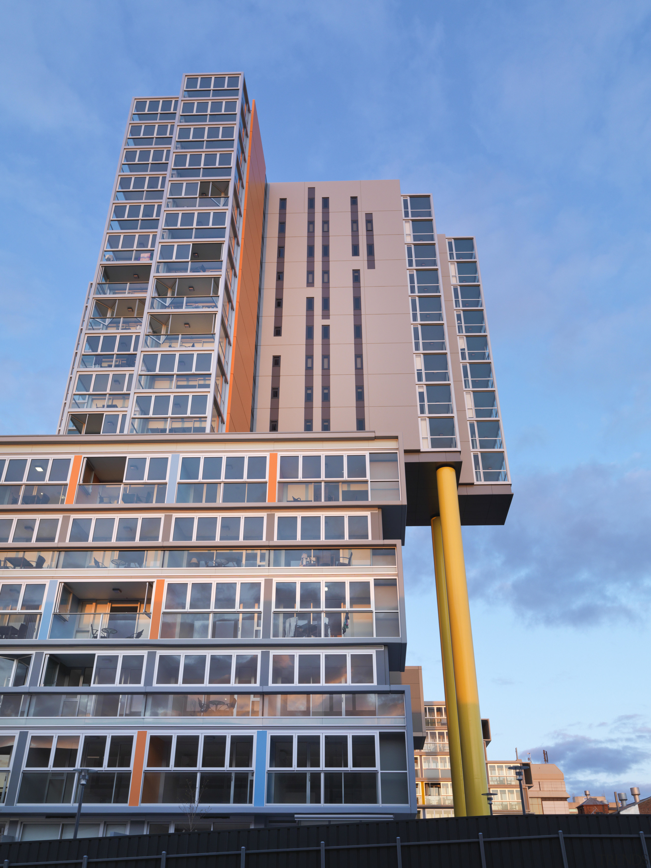 Exterior view of the Altitude in the Precinct apartment, architecture, building, city, commercial building, condominium, corporate headquarters, daytime, downtown, facade, headquarters, landmark, metropolis, metropolitan area, mixed use, neighbourhood, real estate, residential area, sky, skyscraper, tower block, urban area, window, teal