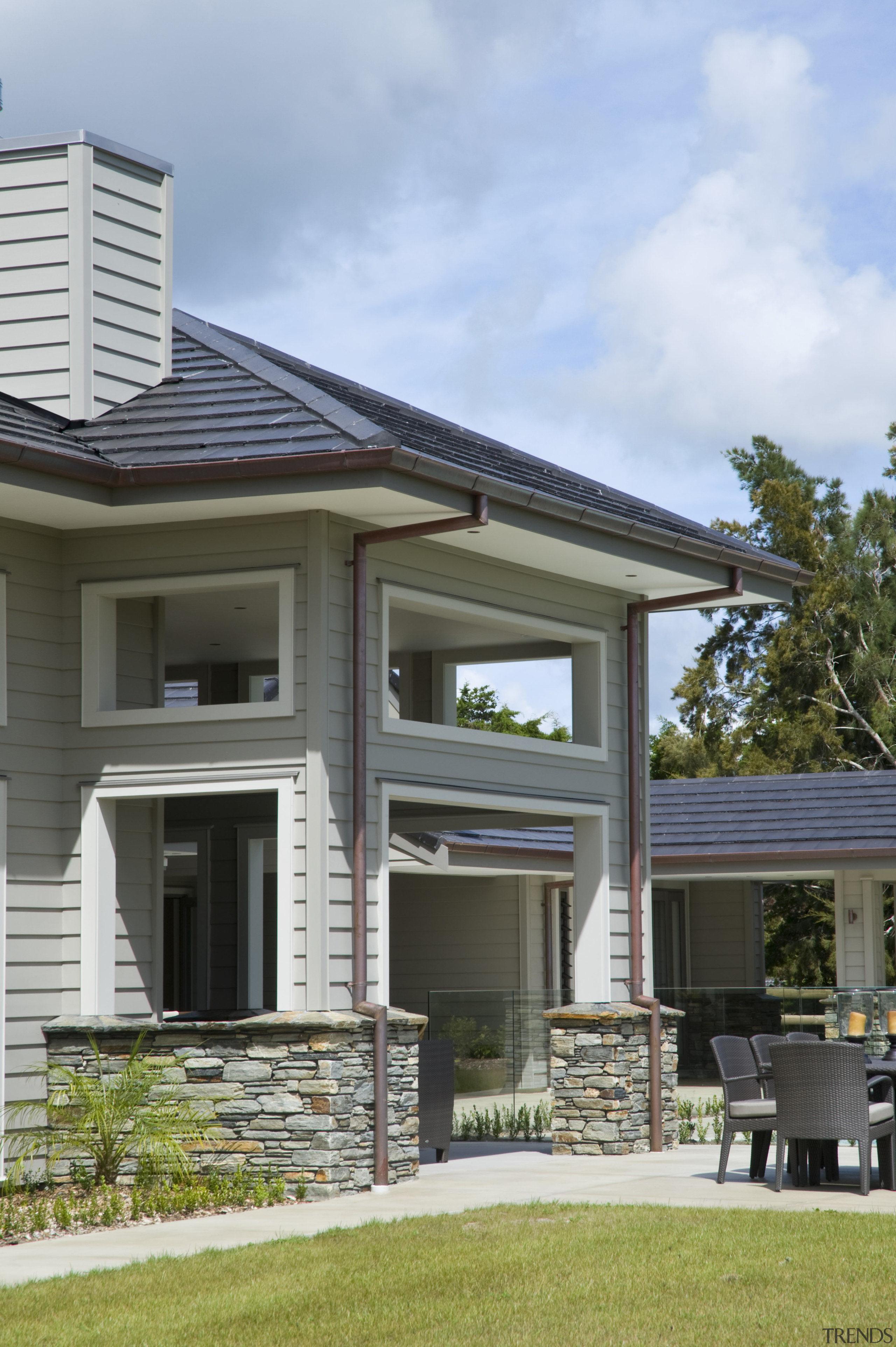 Image of this family home which creates a backyard, cottage, elevation, estate, facade, home, house, outdoor structure, porch, property, real estate, residential area, roof, siding, gray, teal