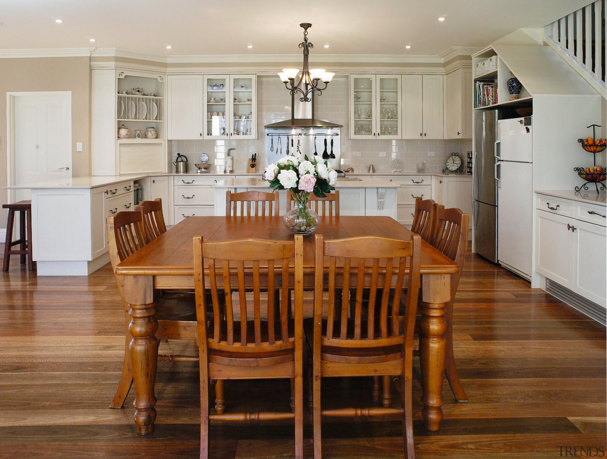 A view of a kitchen designed by Nouvelle cabinetry, chair, countertop, cuisine classique, dining room, floor, flooring, furniture, hardwood, interior design, kitchen, laminate flooring, living room, room, table, wood, wood flooring, brown, gray