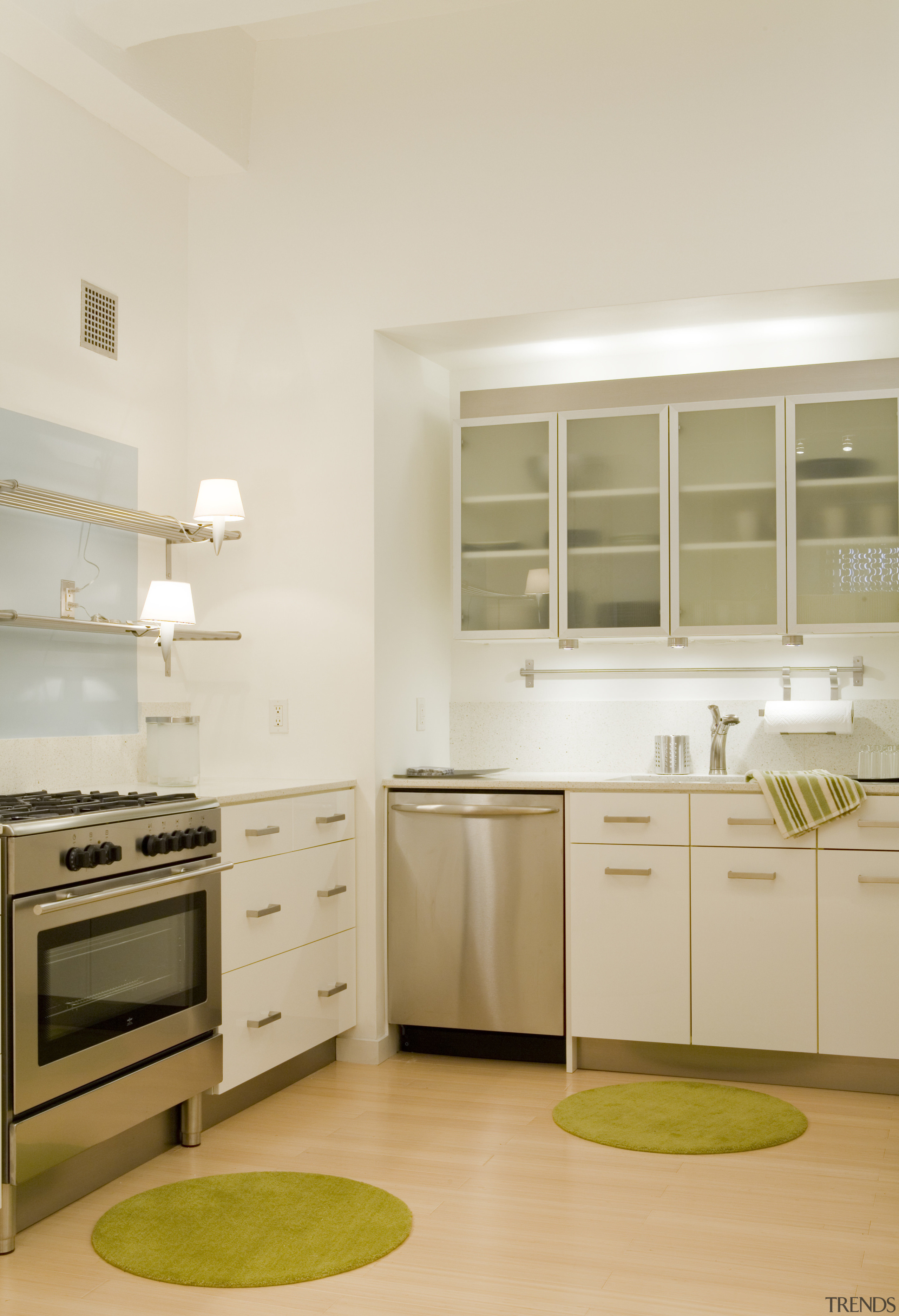 This apartment kitchen includes playful touches such as cabinetry, countertop, cuisine classique, floor, home appliance, interior design, kitchen, room, white