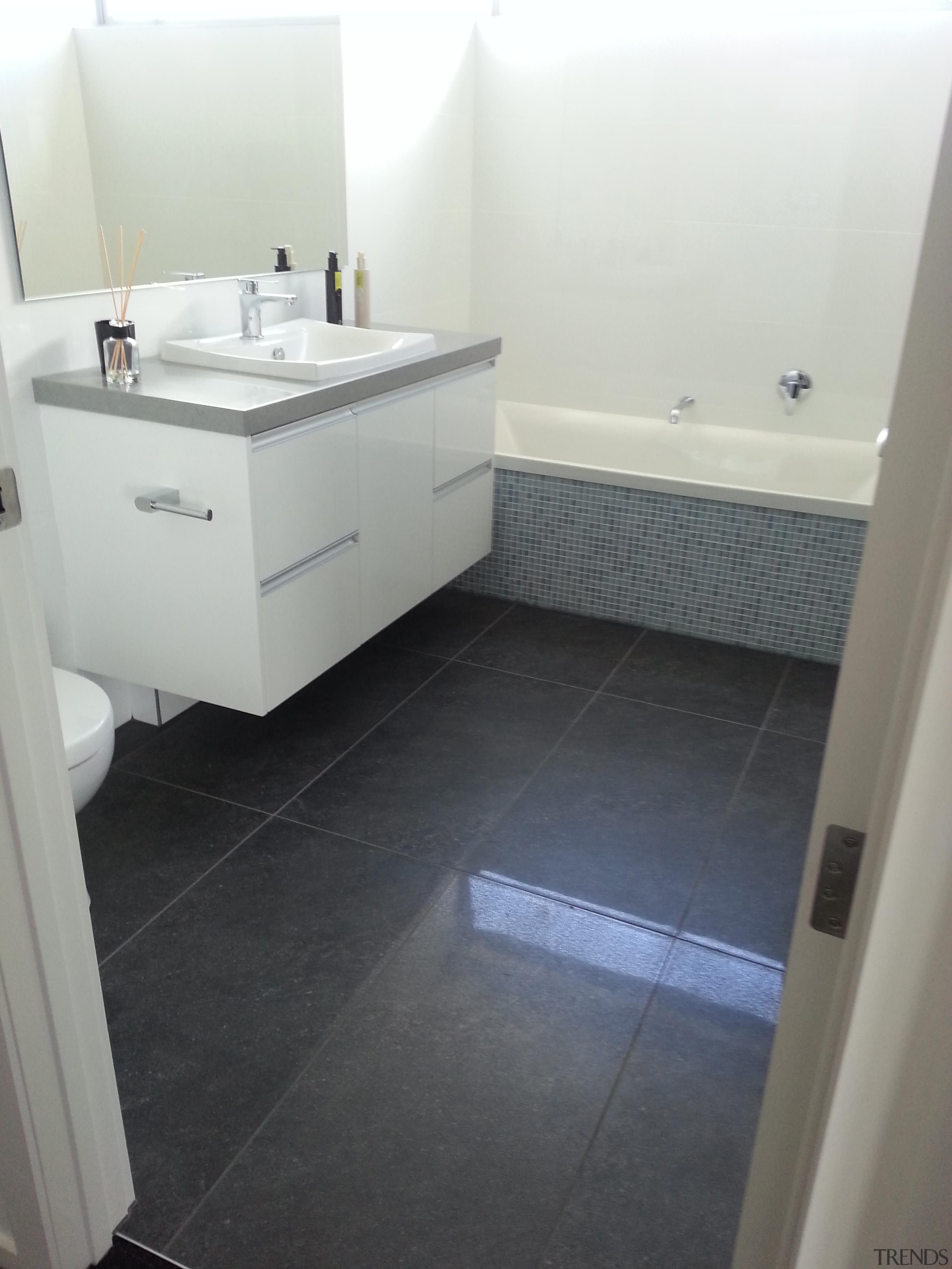 Anthracite bathroom floor with Bisazza Luisa bath feature. bathroom, bathroom accessory, bathroom cabinet, floor, flooring, hardwood, home, laminate flooring, product, property, room, sink, tile, wood flooring, white, gray, black