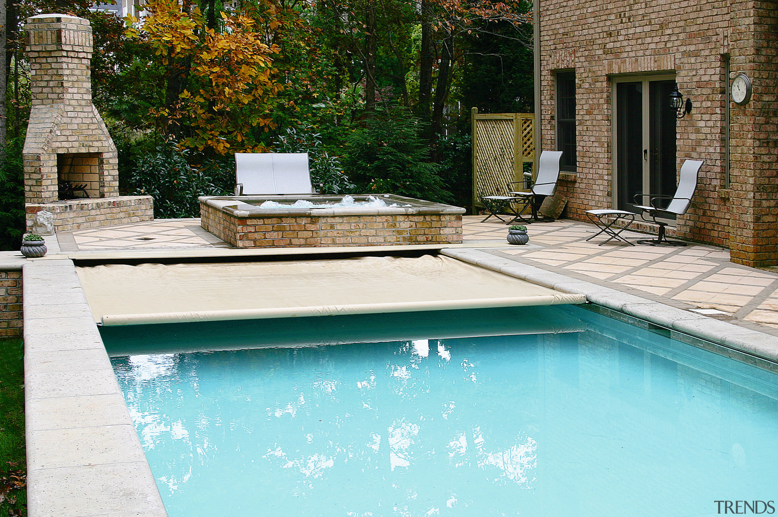 A view of a swimming pool. - A backyard, home, house, leisure, outdoor furniture, outdoor structure, real estate, reflection, residential area, swimming pool, water, water feature, wood, yard, teal, white