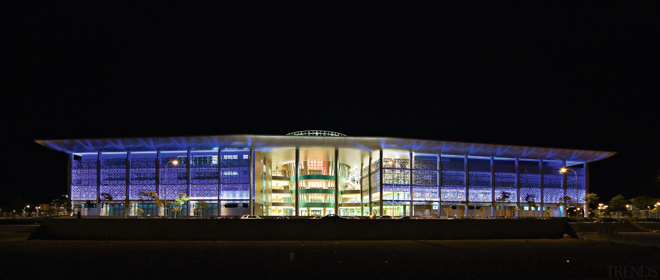 view of the exterior and glass facade of architecture, building, convention center, corporate headquarters, facade, light, lighting, night, opera, performing arts center, sport venue, stage, structure, tourist attraction, black