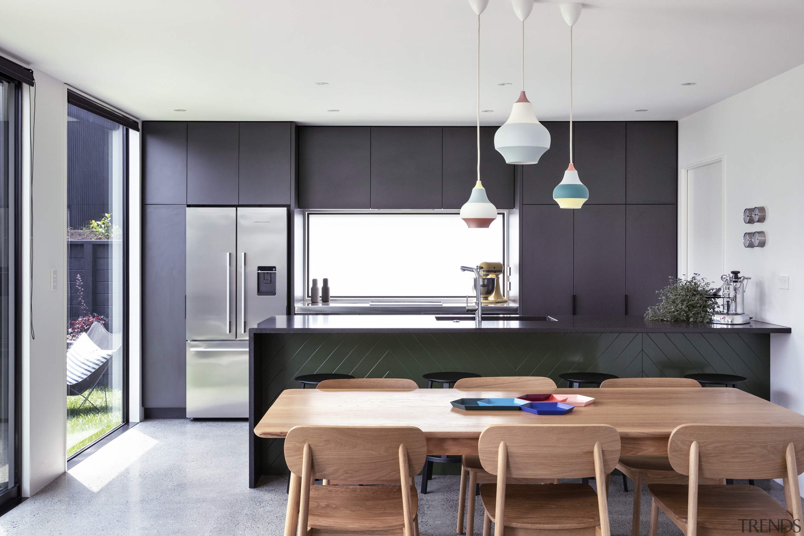 The grey-toned cabinetry complements the home's black metal 