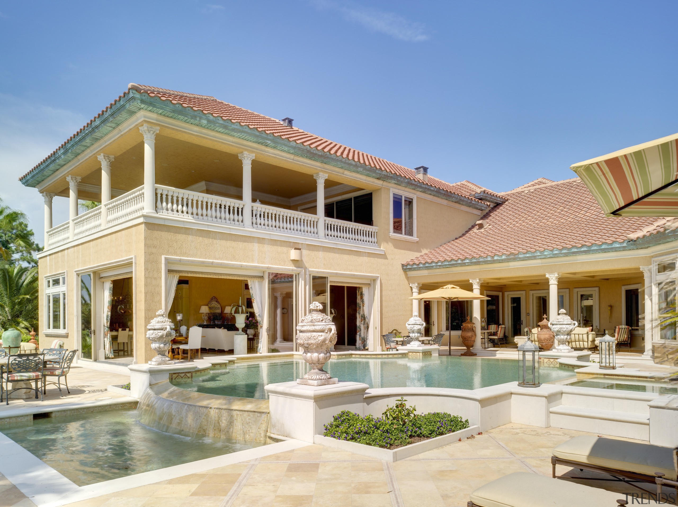 Exterior view of an Italian villa-styled waterfront home. elevation, estate, facade, hacienda, home, house, mansion, property, real estate, residential area, resort, roof, swimming pool, villa, window, teal