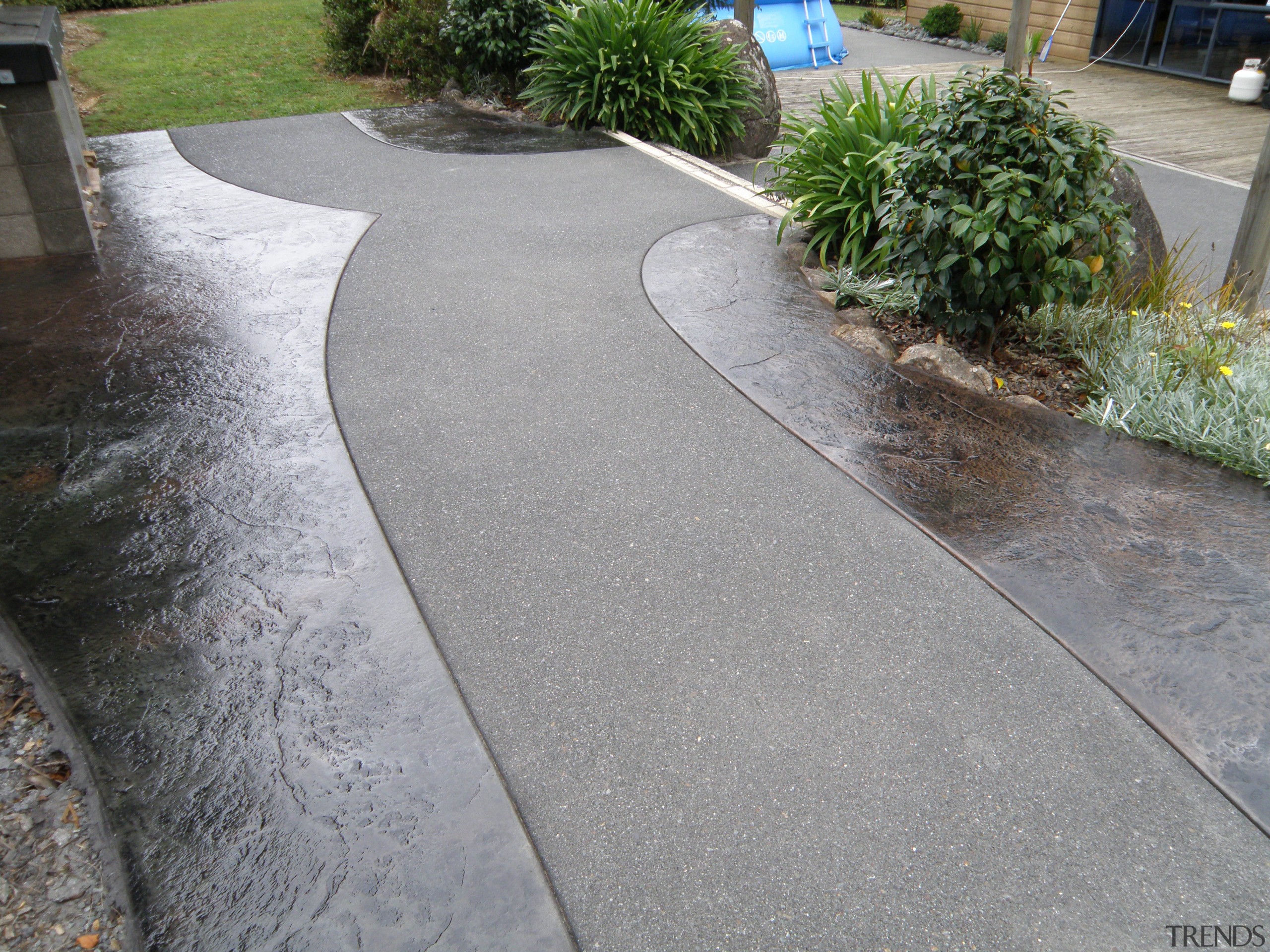 This outdoor area features concrete stamped by Permacolour asphalt, concrete, driveway, flagstone, path, road surface, walkway, gray