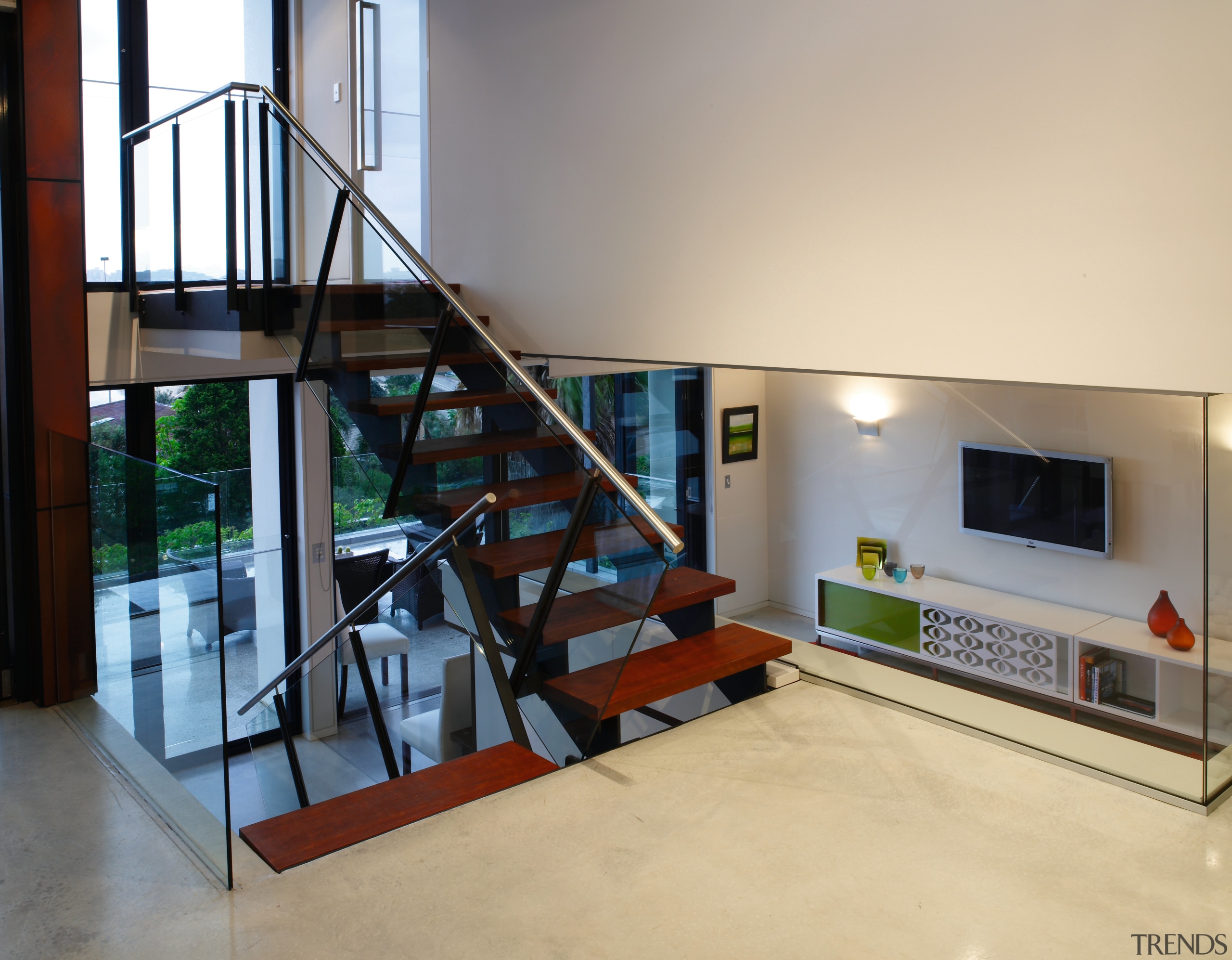 A view of the staircase featuring stainless steel floor, flooring, handrail, house, interior design, loft, stairs, orange