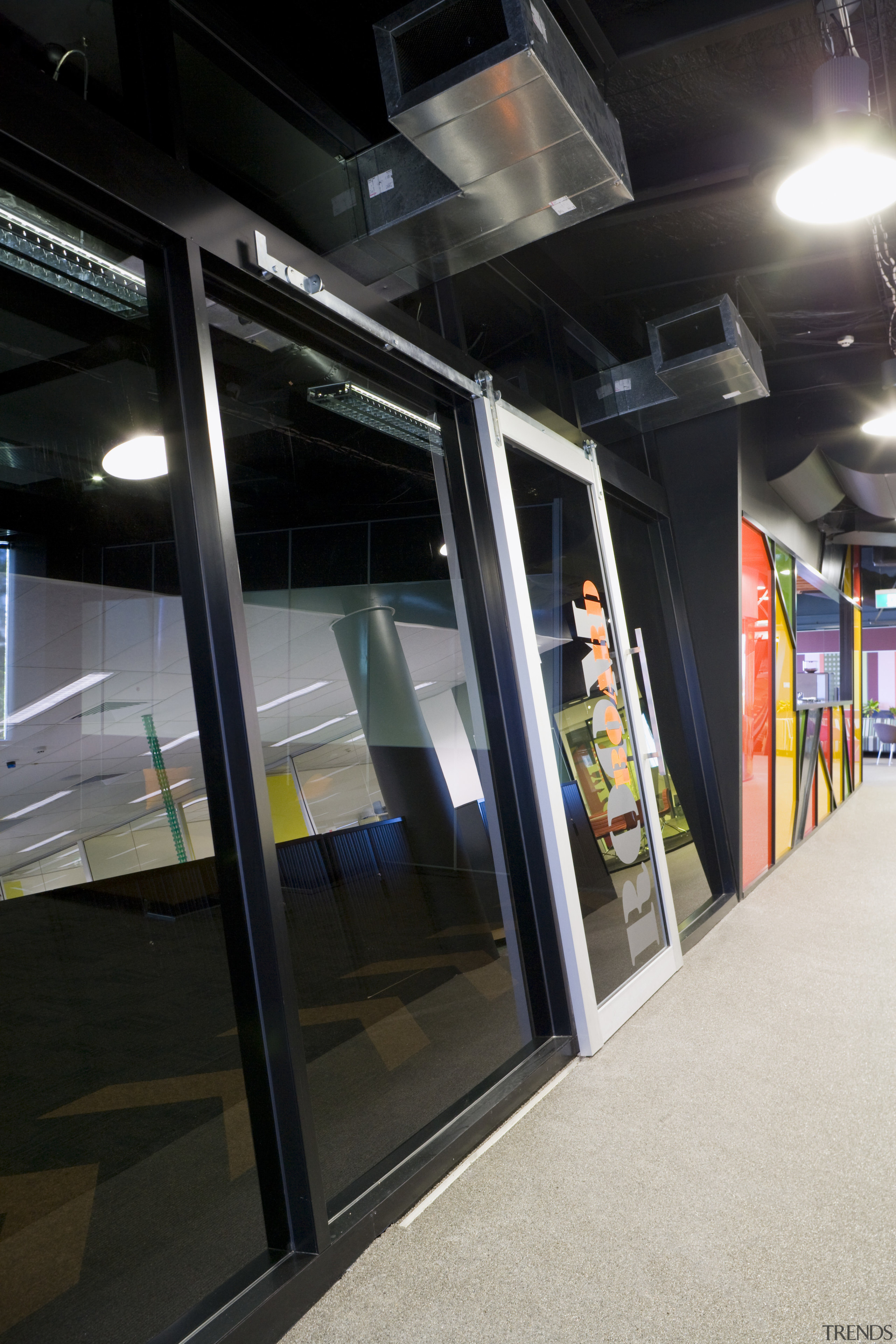 View of slanted glass doors which lead into glass, public transport, black, gray