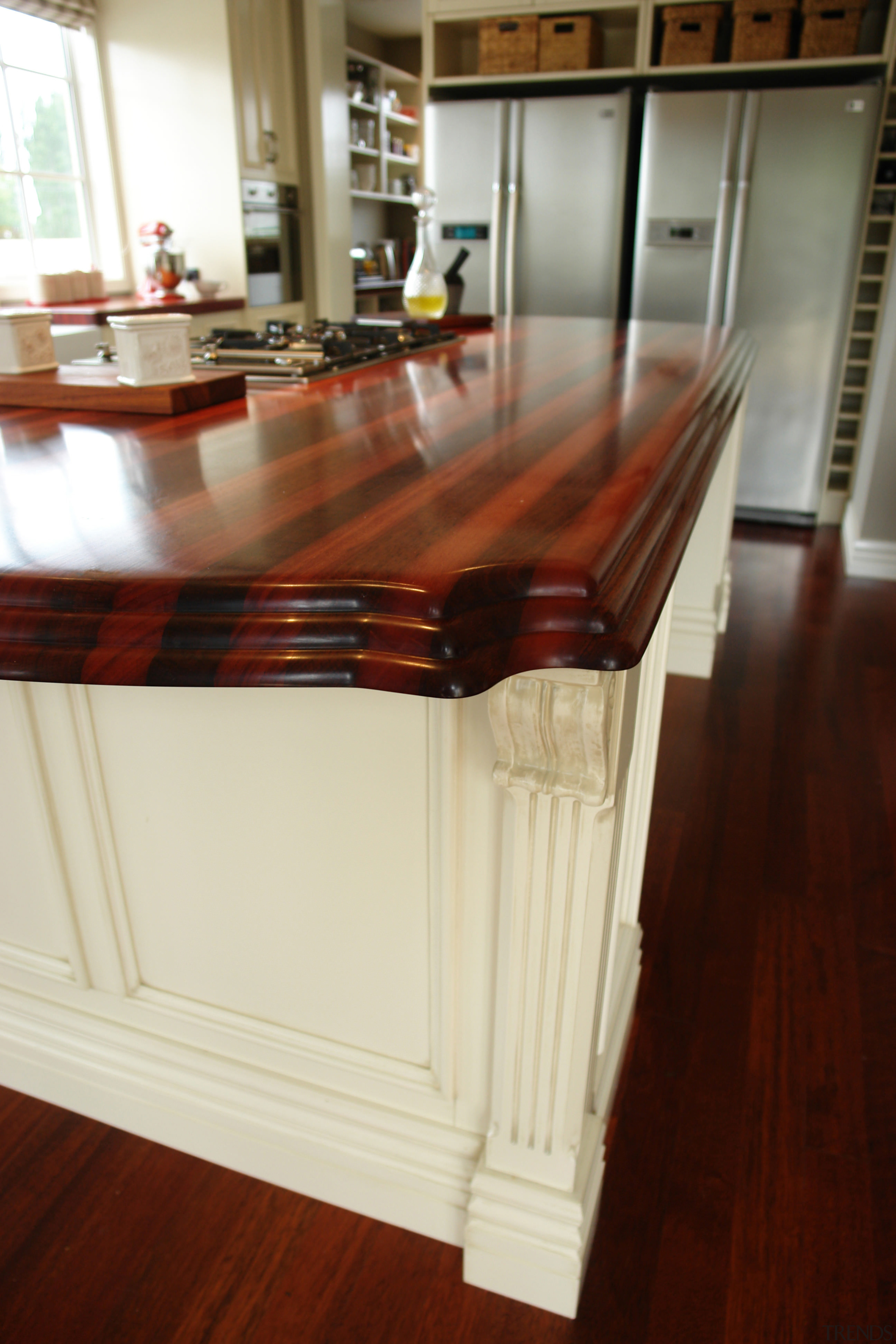 View of a kitchen designed by Millbrook Kitchens cabinetry, chest of drawers, countertop, drawer, floor, flooring, furniture, hardwood, interior design, kitchen, laminate flooring, molding, room, table, wood, wood flooring, wood stain, white, red