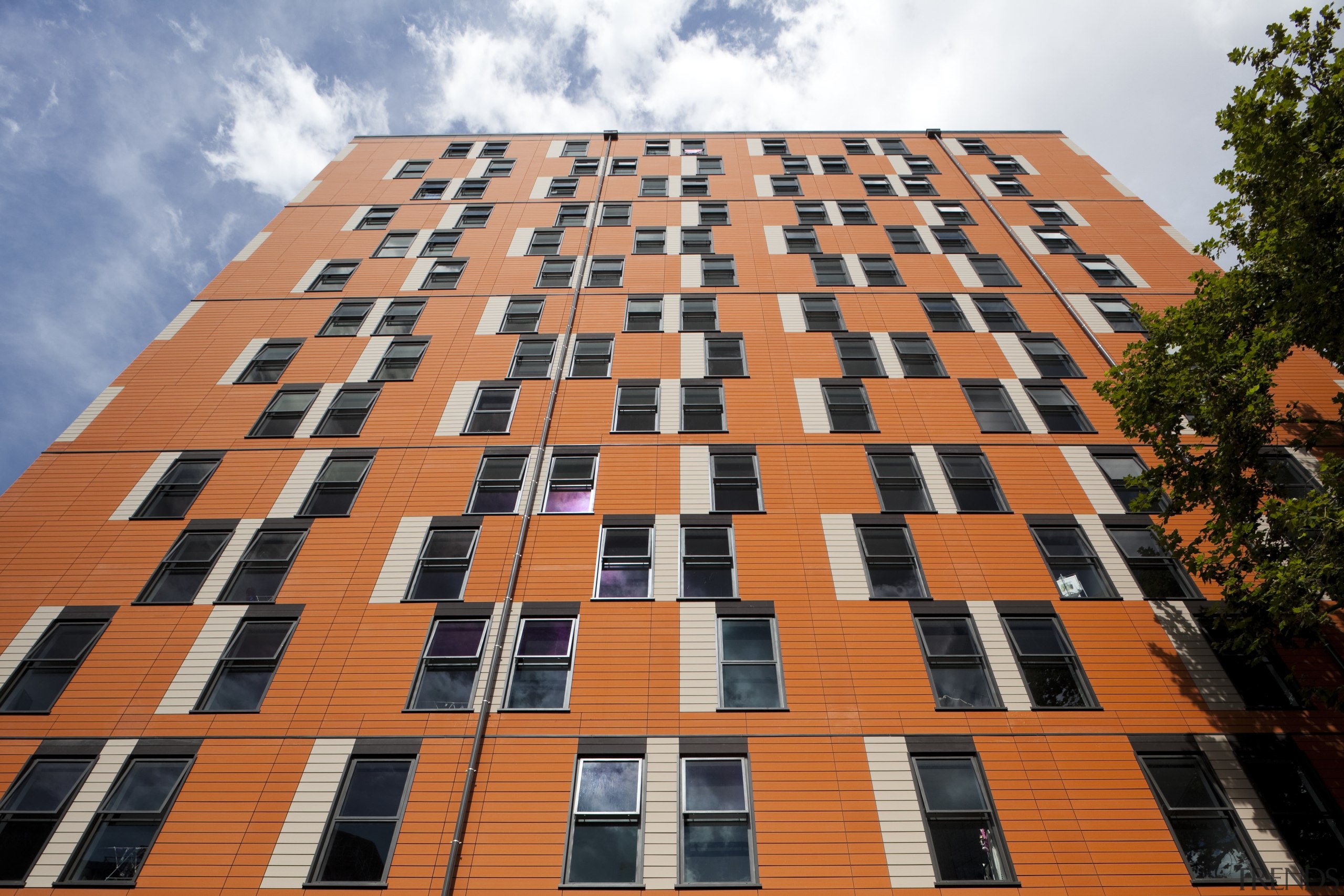 View of exterior with orange and white pattern. architecture, brick, building, city, commercial building, condominium, daytime, facade, house, landmark, line, metropolis, metropolitan area, residential area, roof, sky, tower block, urban area, orange