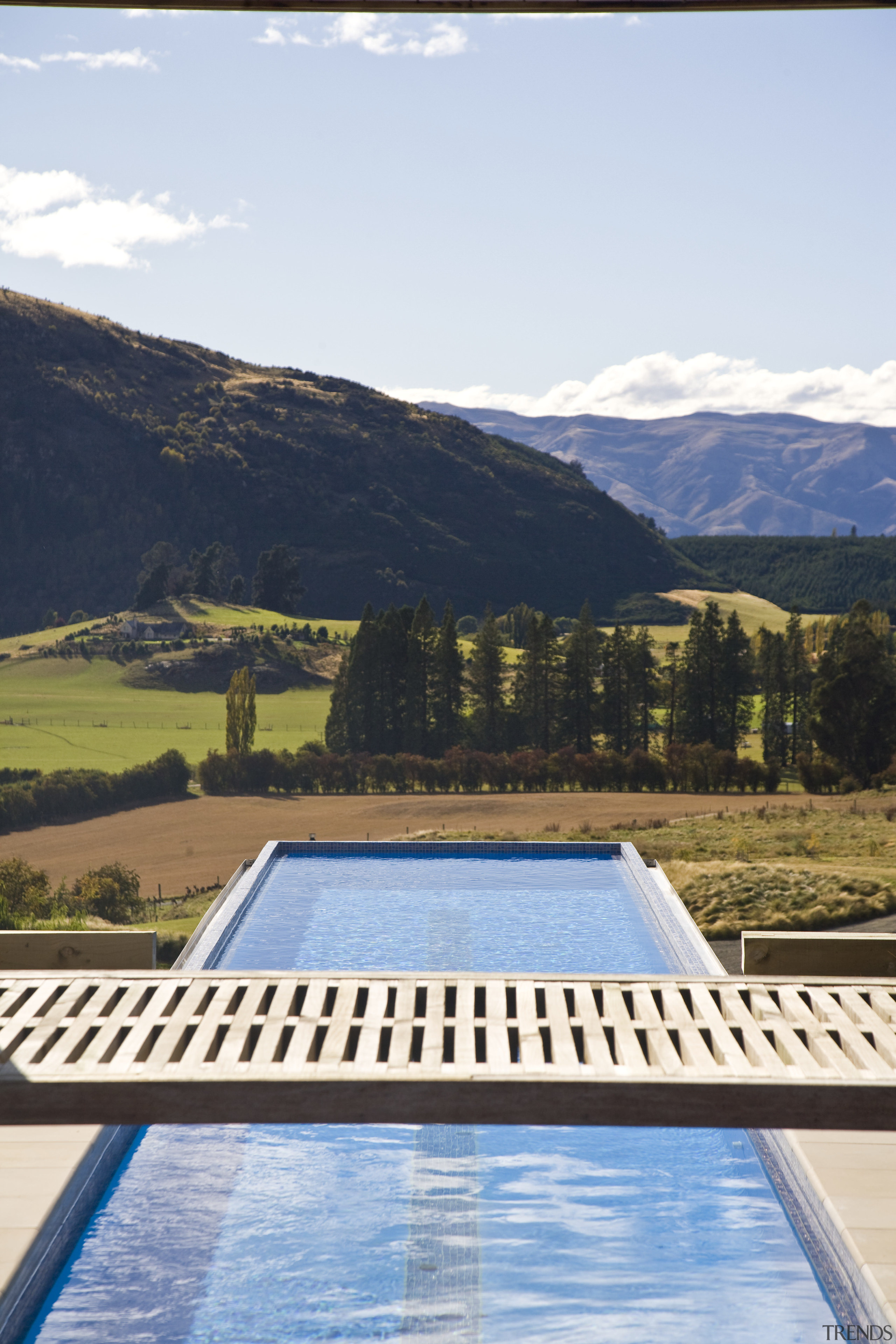 Exterior view of the outdoor area which features cloud, daylighting, estate, house, leisure, mountain, mountain range, property, real estate, reflection, roof, sky, swimming pool, water, white