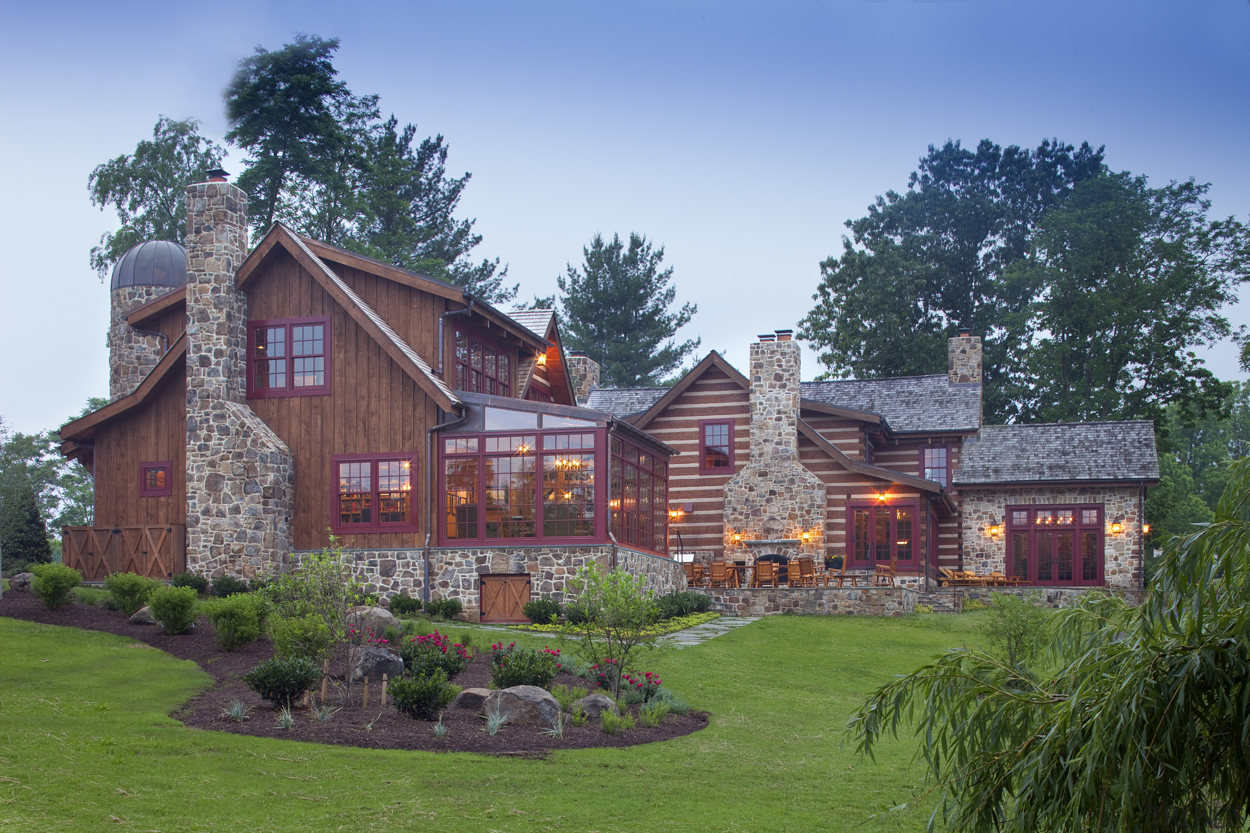 View of large wooden home with stone chimneys cottage, estate, facade, farmhouse, grass, home, house, landscape, landscaping, mansion, plant, property, real estate, residential area, sky, suburb, tree, teal