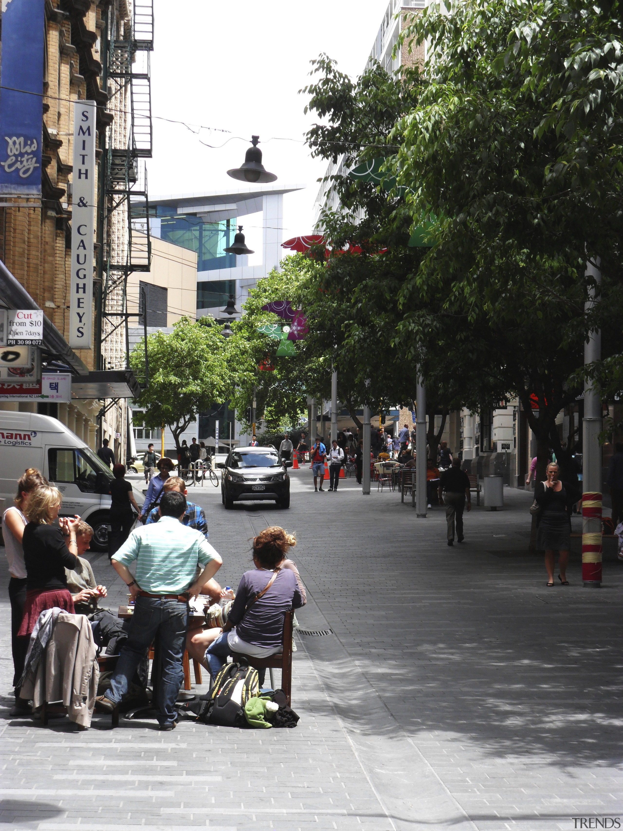 People-friendly streetscapes are revitalising our cities, as the car, city, downtown, infrastructure, land vehicle, lane, metropolitan area, neighbourhood, pedestrian, plant, public space, recreation, road, street, town, town square, tree, urban area, vehicle, black, white