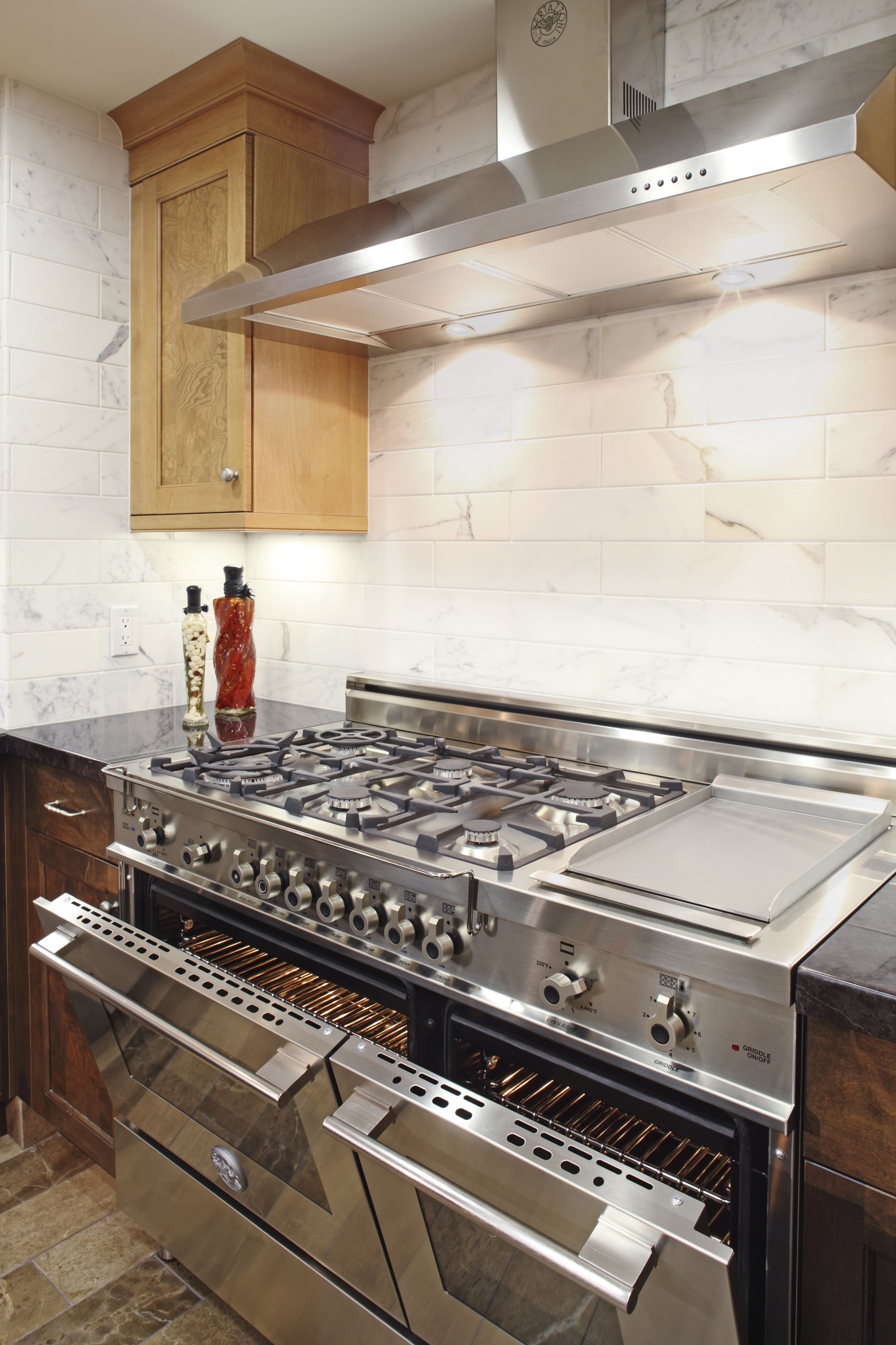 View of a contemporary kitchen which features a countertop, floor, flooring, kitchen, kitchen appliance, white
