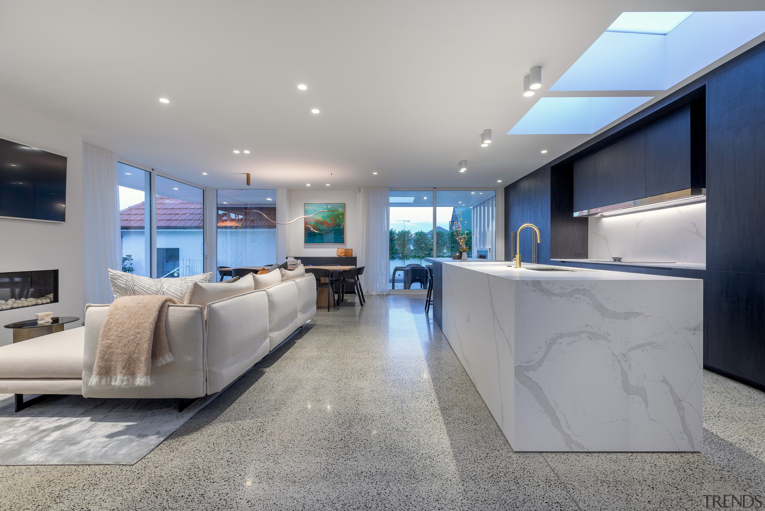 A light-toned, marble-look island together with the skylights 