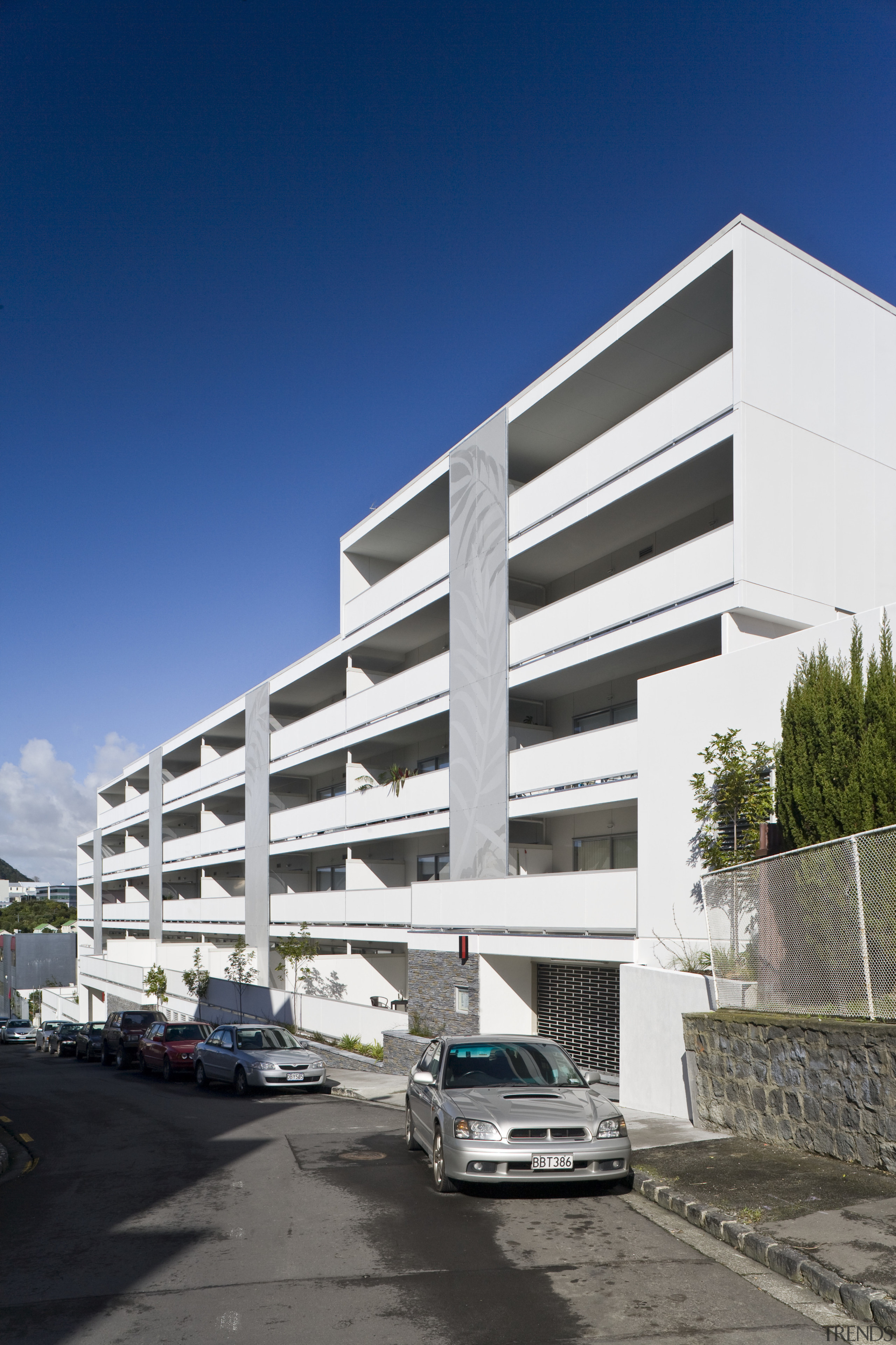 Exterior view of the Ivory apartments which features apartment, architecture, building, commercial building, condominium, corporate headquarters, elevation, facade, headquarters, house, mixed use, neighbourhood, parking, parking lot, property, real estate, residential area, sky, blue, white