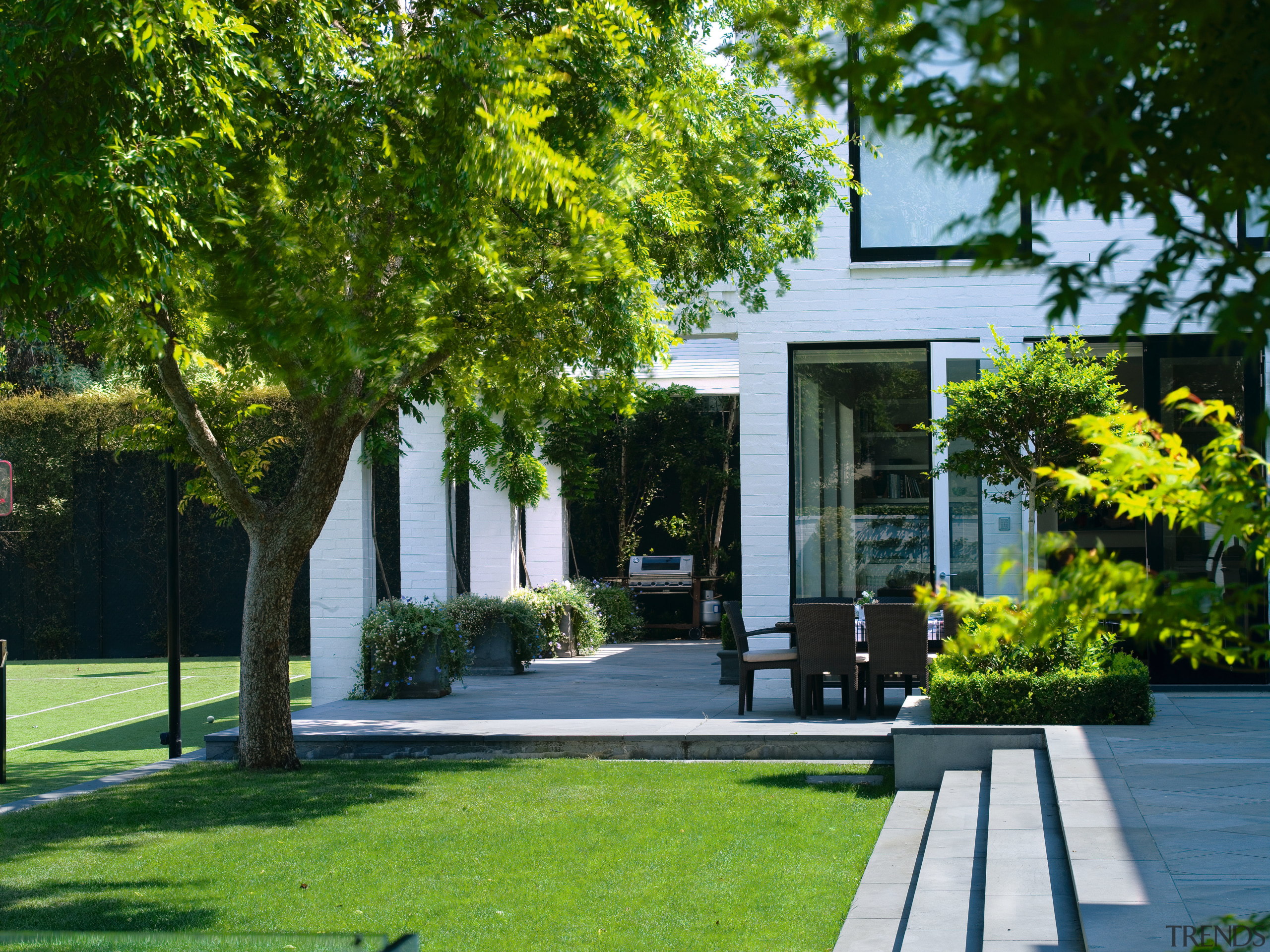 A view of the outdoor entertaining area featuring architecture, courtyard, estate, facade, garden, grass, home, house, landscape, landscaping, lawn, neighbourhood, outdoor structure, plant, property, real estate, residential area, tree, walkway, yard, green