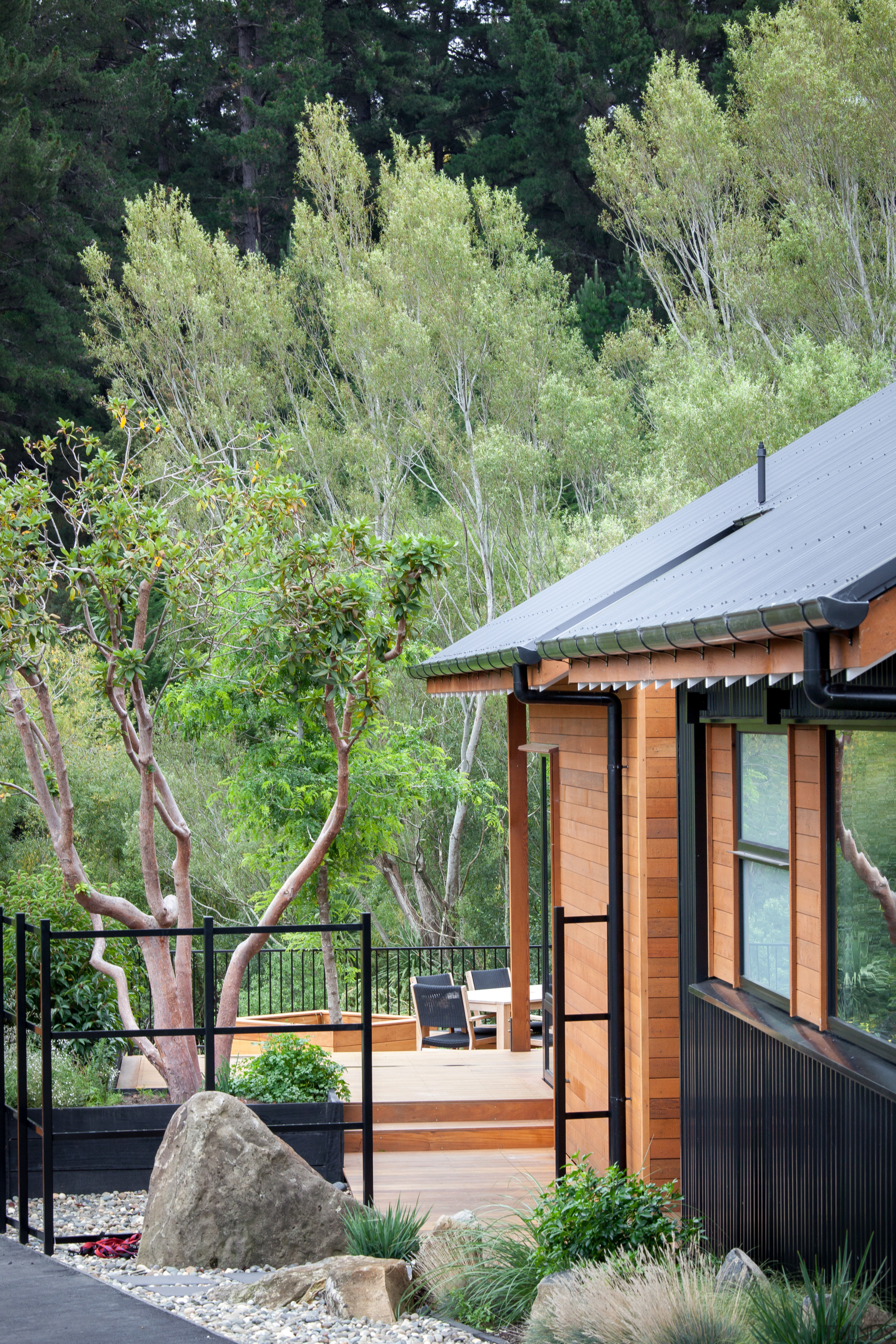 Approaching along the side of this home by architecture, backyard, cottage, home, house, landscape, outdoor structure, plant, real estate, roof, tree, wood, green