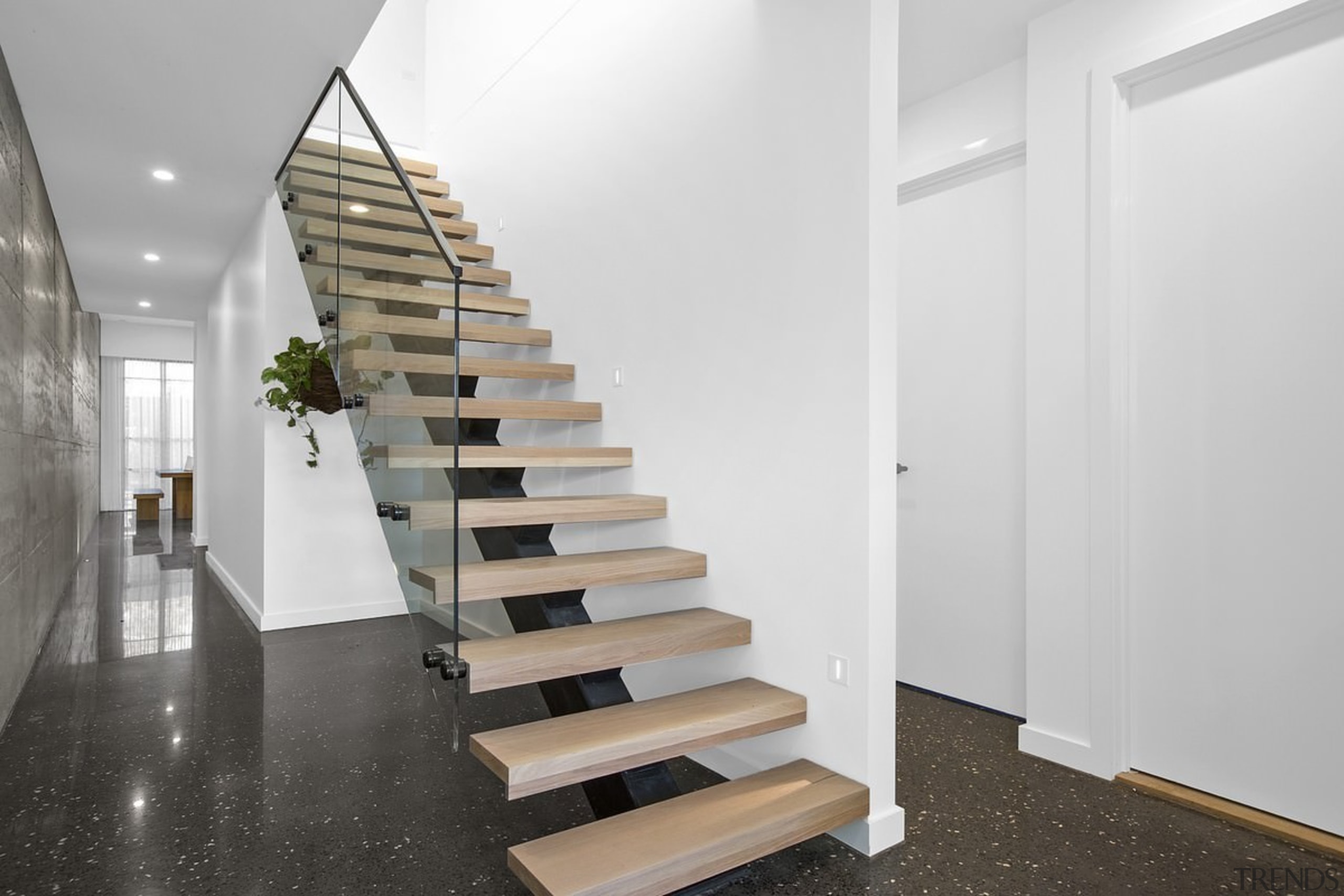 A floating stair with glass balustrade runs up architecture, daylighting, floor, flooring, handrail, interior design, product design, stairs, white