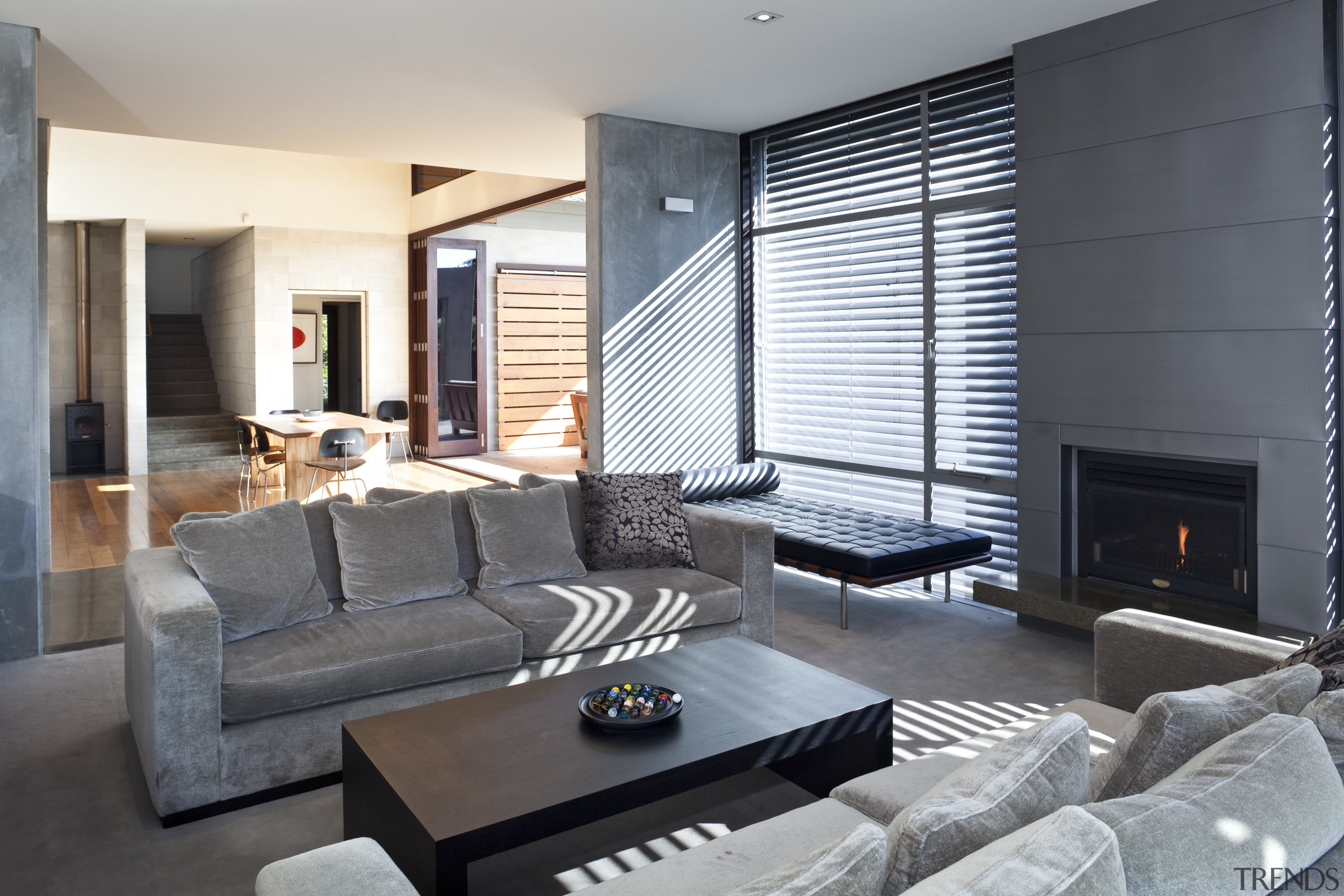 View of lounge featuring sofas, dark stained coffee floor, interior design, living room, property, real estate, room, window, window covering, gray