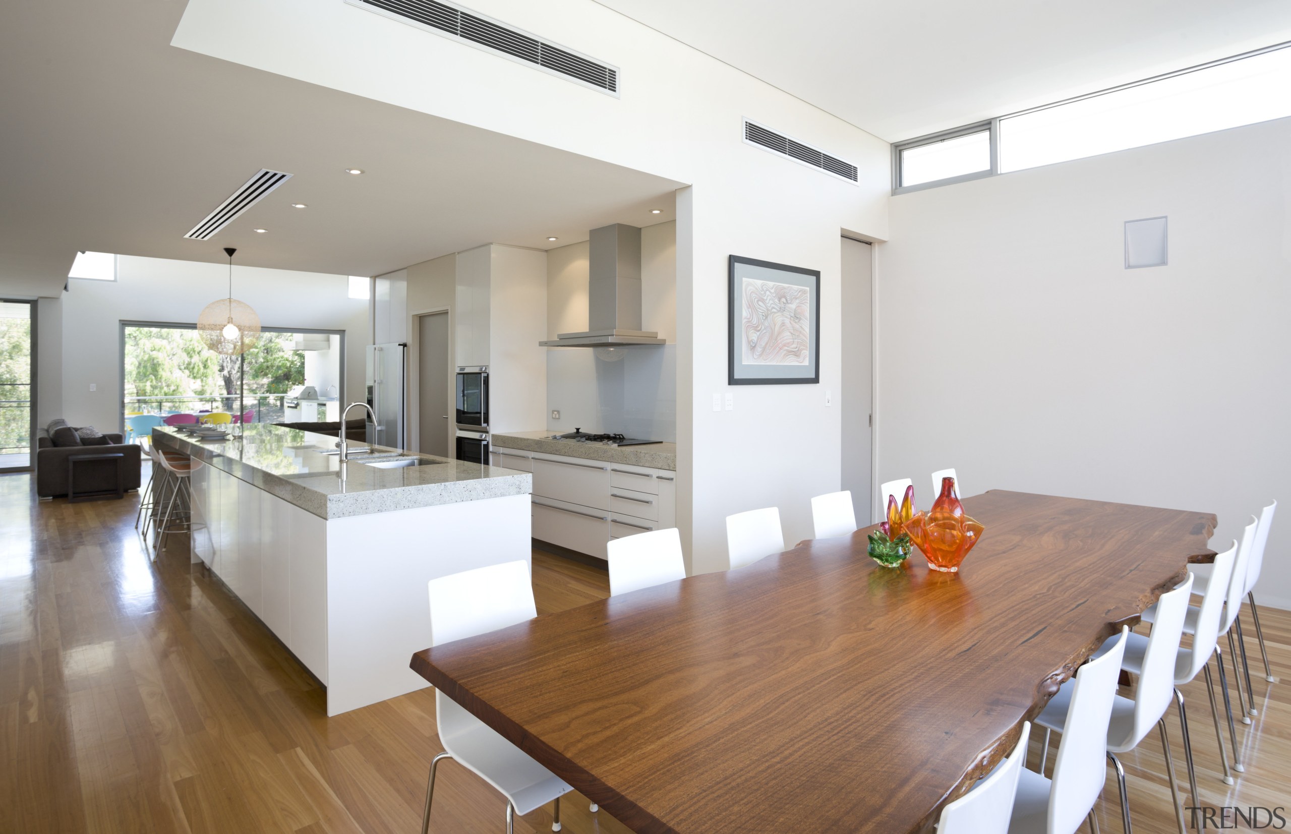 Designed for easy entertaining, this galley-style kitchen is apartment, dining room, floor, flooring, house, interior design, living room, property, real estate, room, table, white