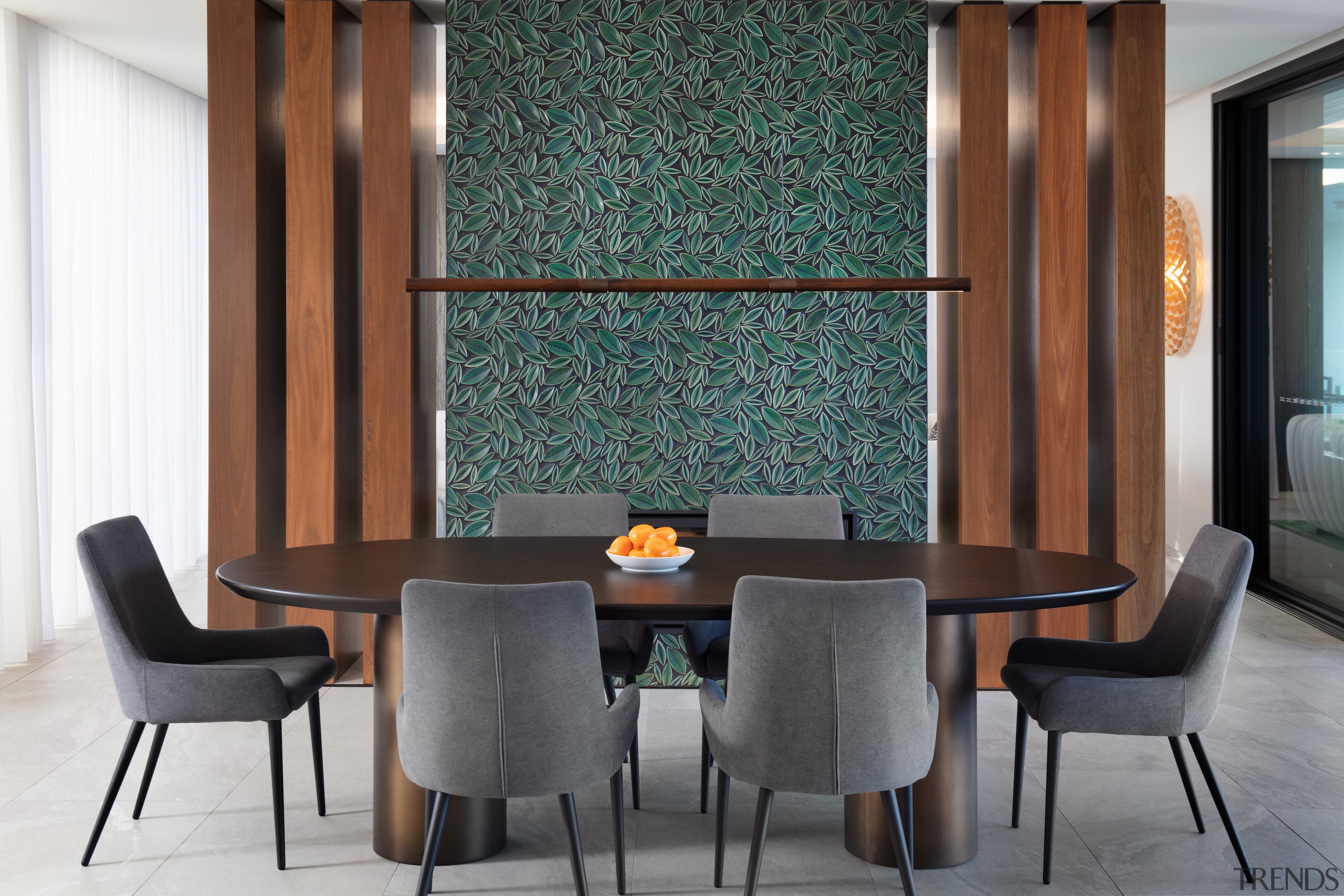 A feature tiled mosaic wall stands between dining 