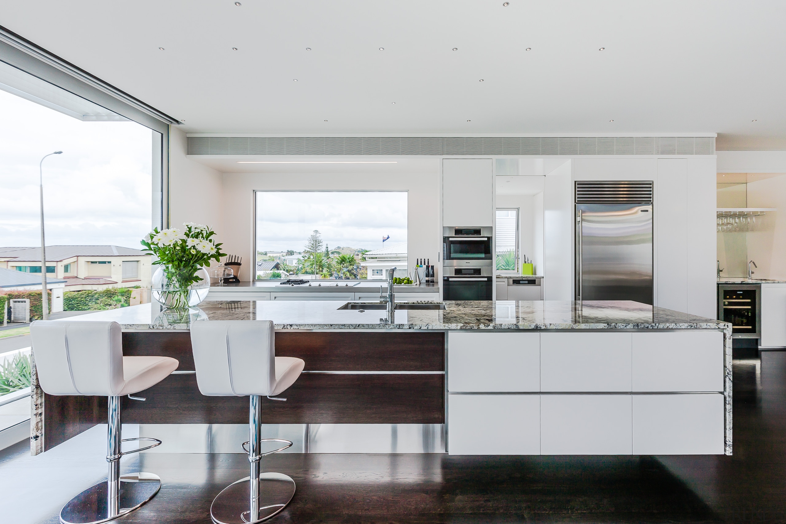 A textural granite benchtop with waterfall ends wraps countertop, interior design, kitchen, table, white