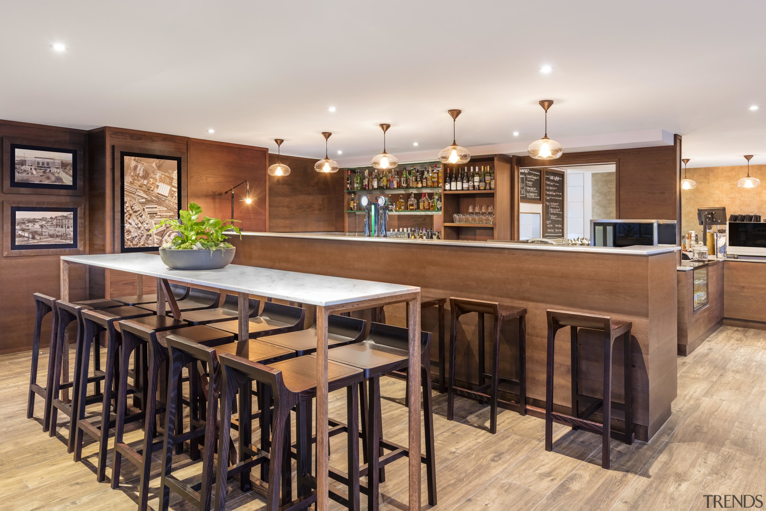 A warm, inviting bar and restaurant greets guests countertop, flooring, interior design, kitchen, real estate, table, white