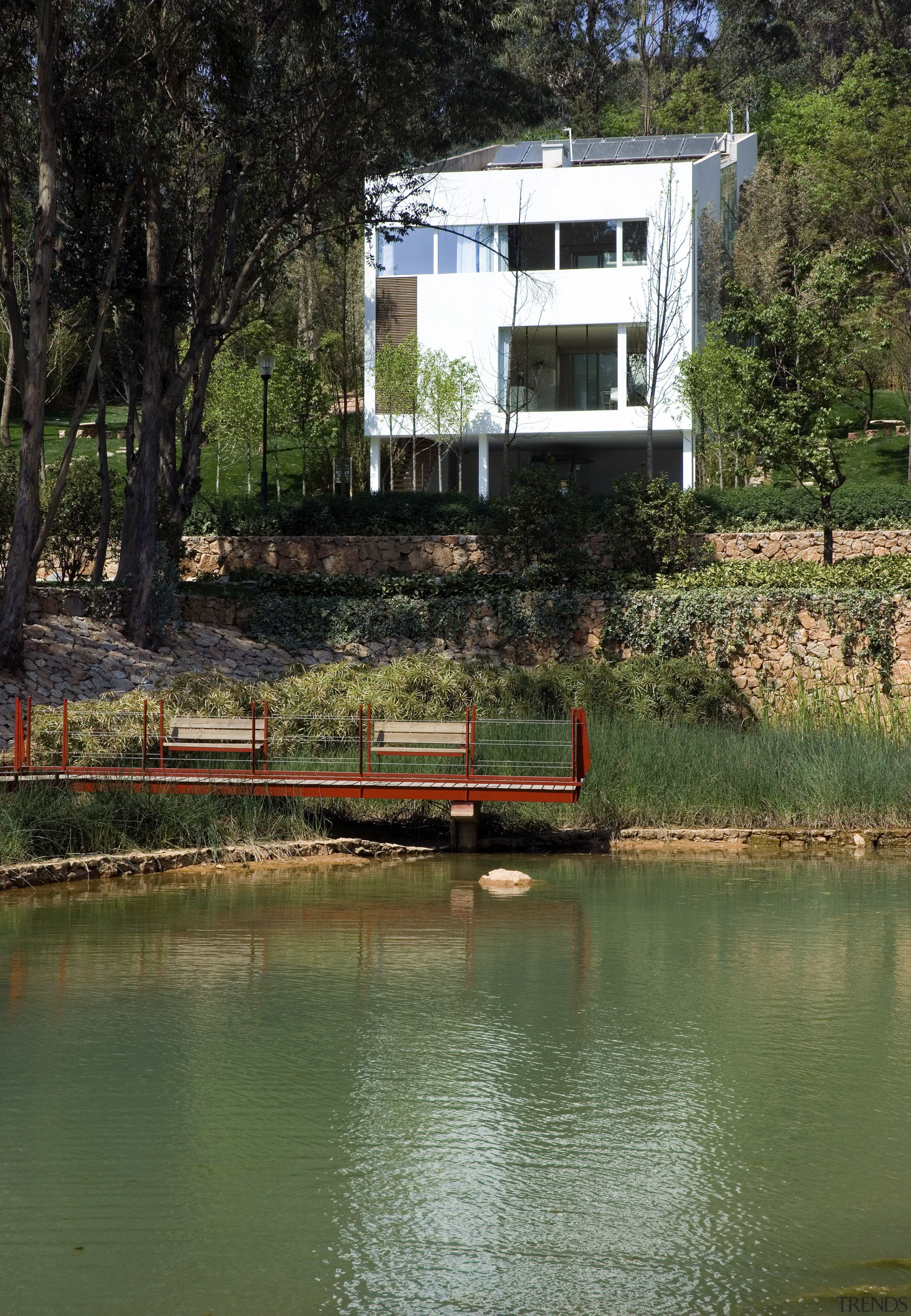 Exterior view of a house in the environmentally bank, body of water, cottage, home, house, lake, plant, pond, real estate, reflection, river, sky, tree, water, waterway, brown