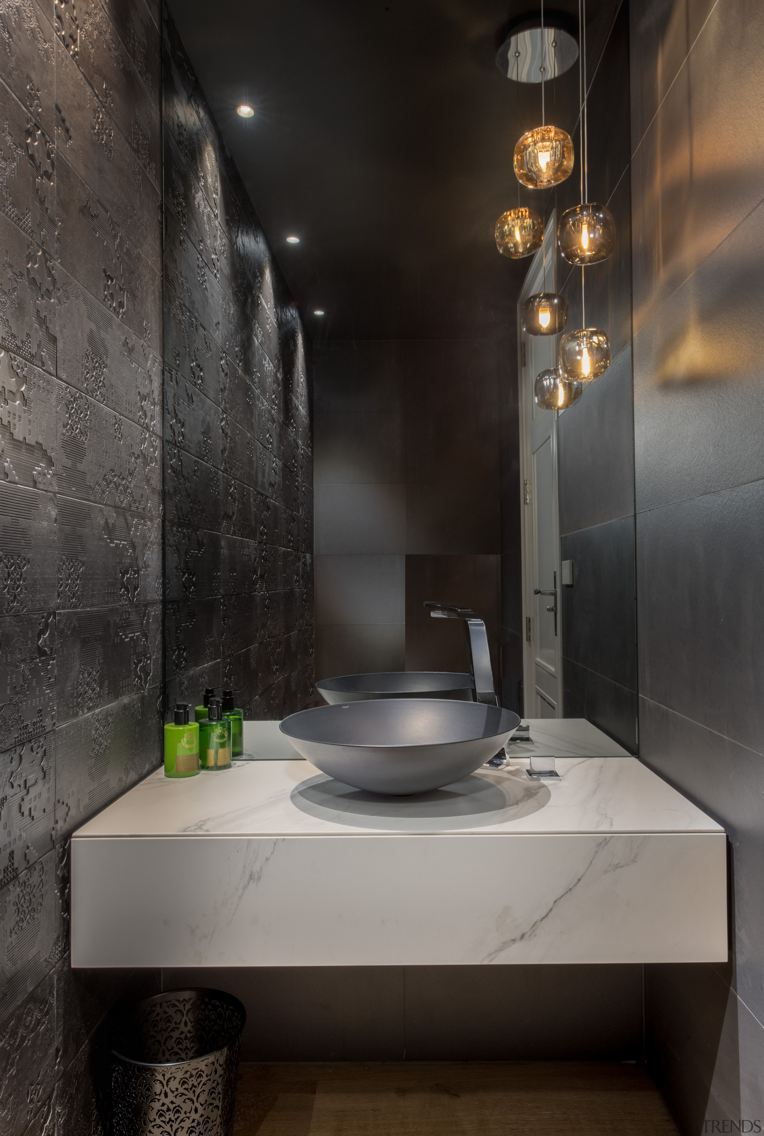 This surprising, dark-toned powder room has a stone 