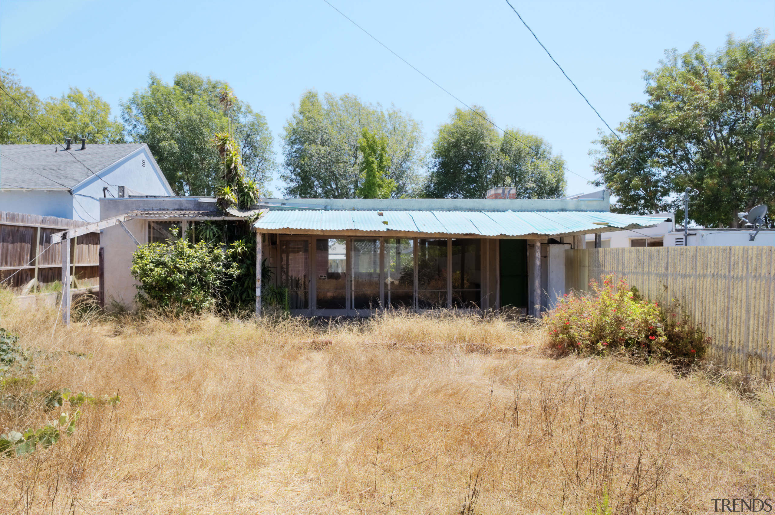 Exterior view of this contemporary home that was cottage, home, house, land lot, landscape, property, real estate, residential area, rural area, shack, shed, yard, teal, orange