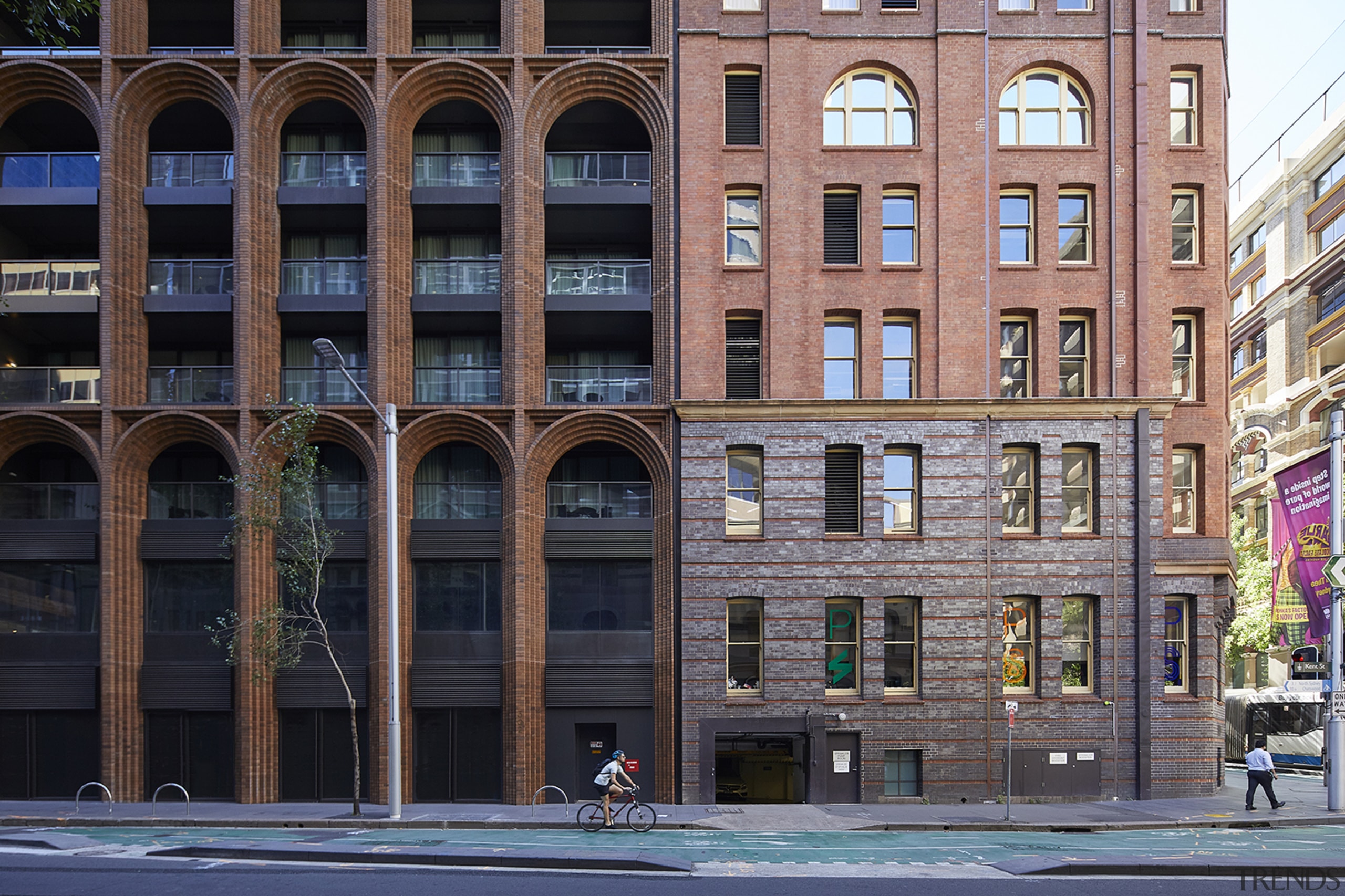 At street level, the mixed-use residential building melds apartment, arch, architecture, building, city, classical architecture, commercial building, condominium, downtown, facade, human settlement, landmark, metropolis, metropolitan area, mixed-use, neighbourhood, real estate, urban area, black, gray