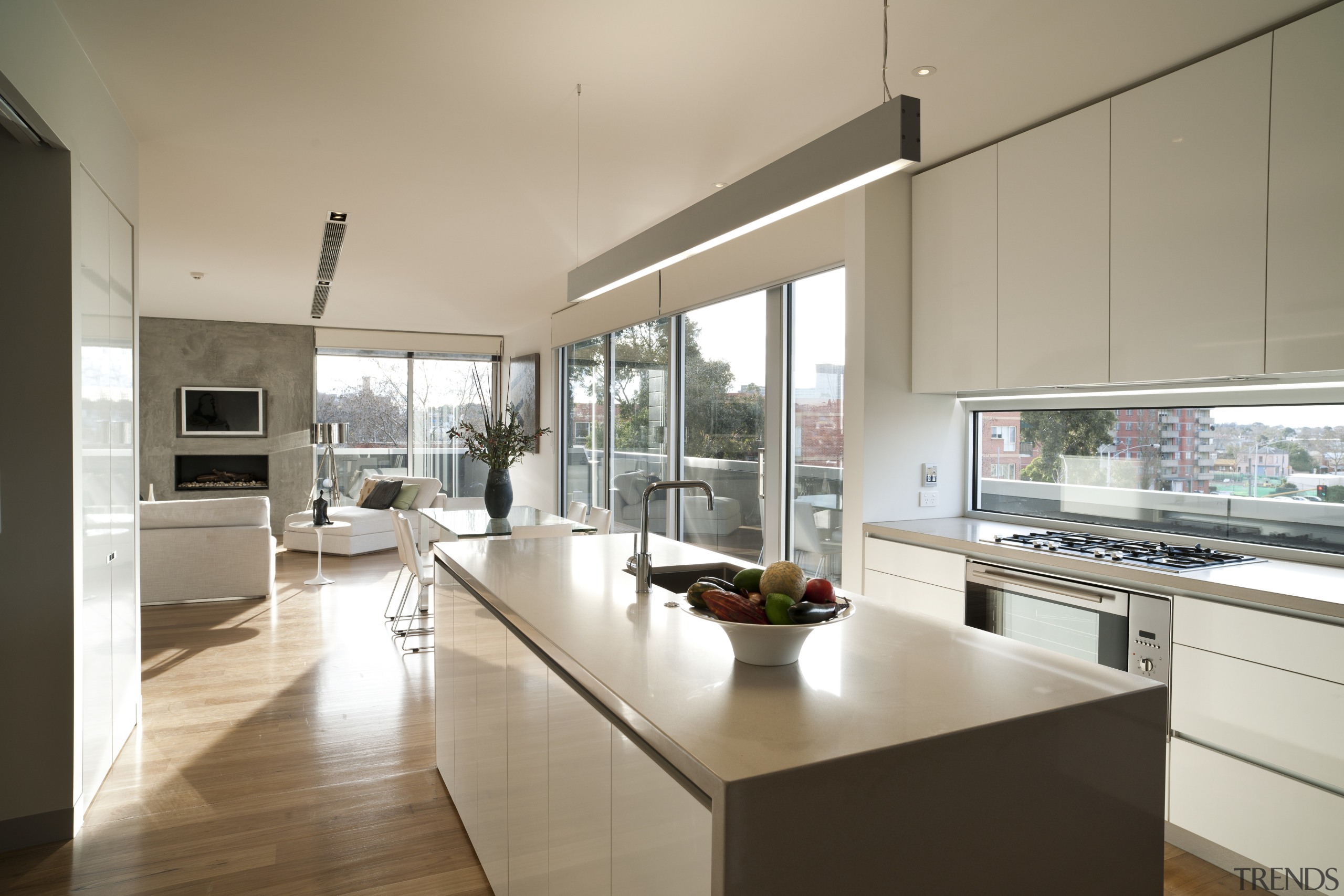 Open-plan penthouse interior with contemporary kitchen featuring waterfall architecture, countertop, house, interior design, kitchen, real estate, gray