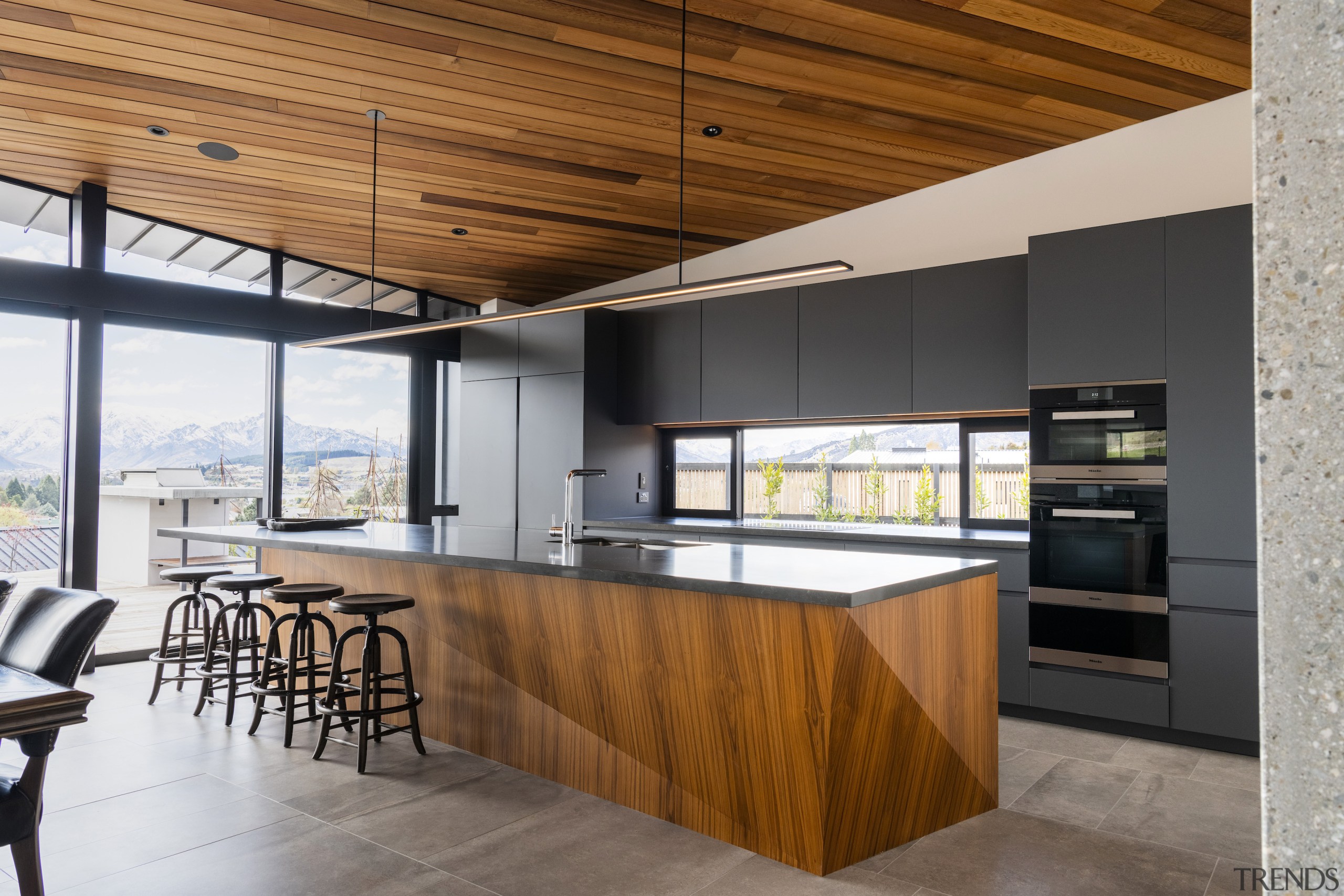 The faceted kitchen island echoes the rich timber 