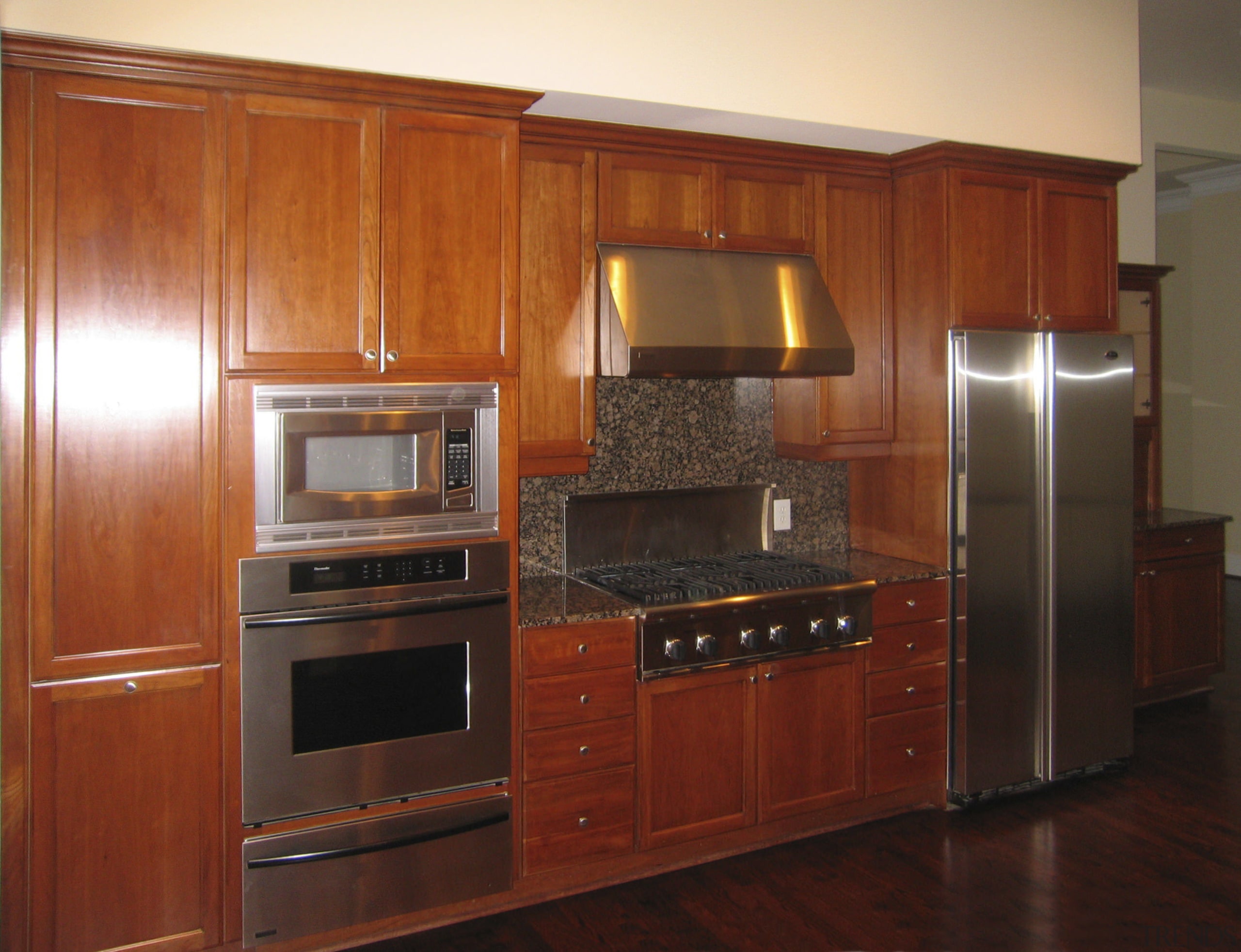 View of the condominiums kitchen before renovation cabinetry, countertop, cuisine classique, floor, flooring, furniture, hardwood, home appliance, interior design, kitchen, room, under cabinet lighting, red