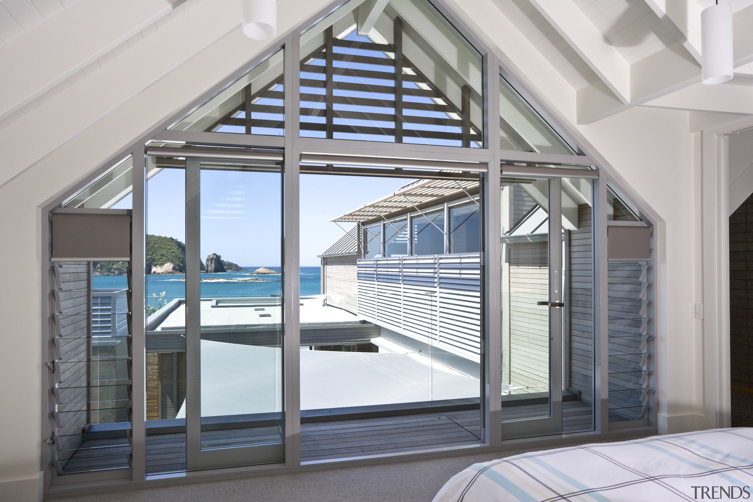 View of bedroom with gabled roof space, glass daylighting, door, glass, real estate, structure, window, gray