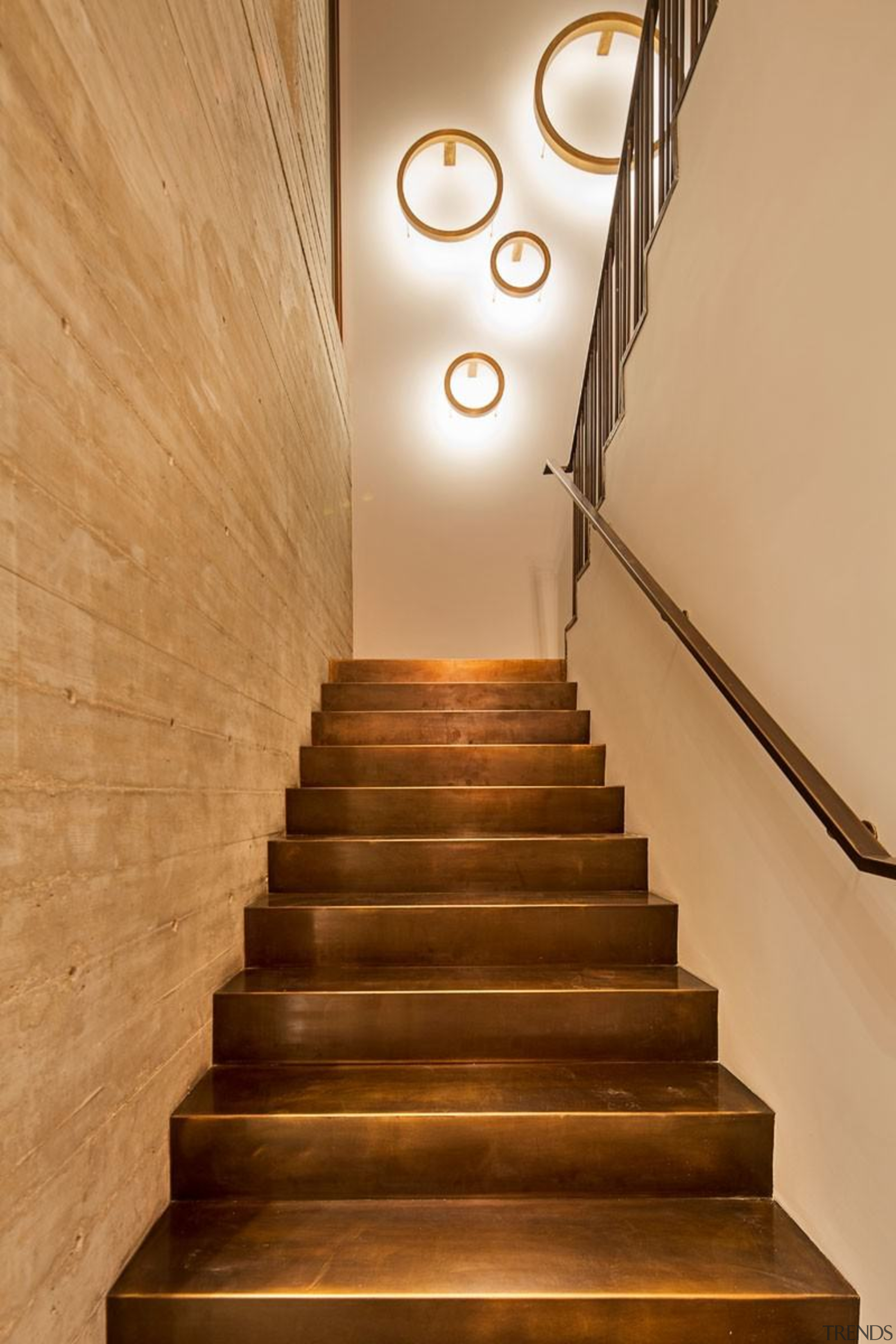 A staircase with bronze stairs and a concrete handrail, interior design, lighting, stairs, orange, brown