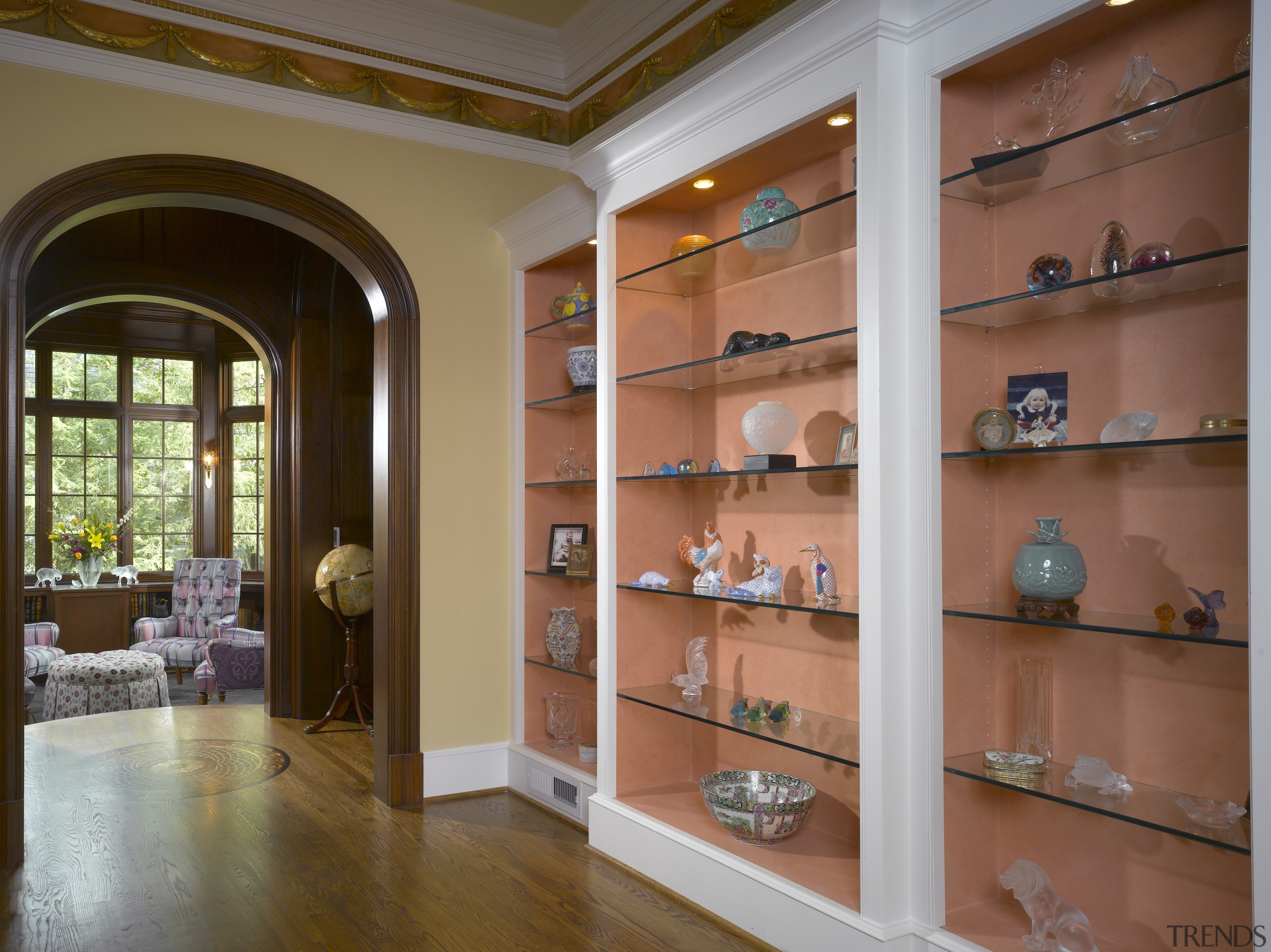 A view of a hallway, wooden flooring, display bookcase, cabinetry, display case, furniture, interior design, lobby, shelf, shelving, red, brown