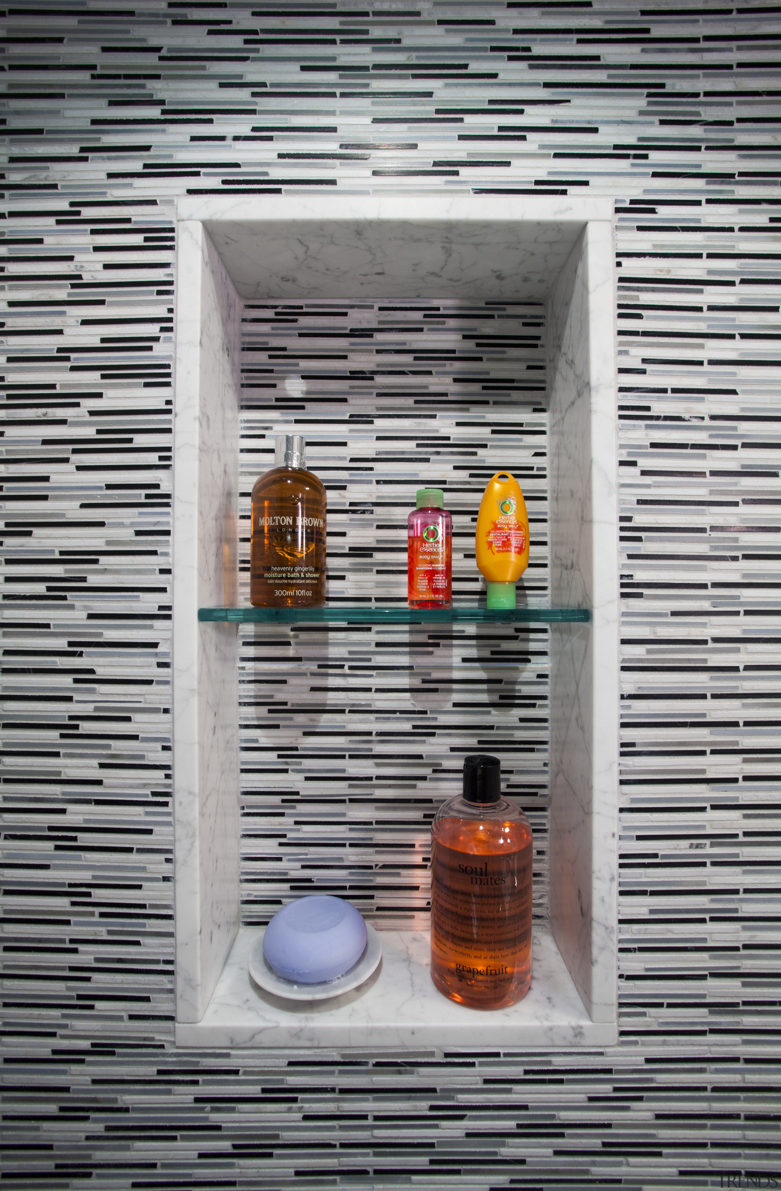 A recessed soap and shampoo niche maximizes usable glass, wall, gray