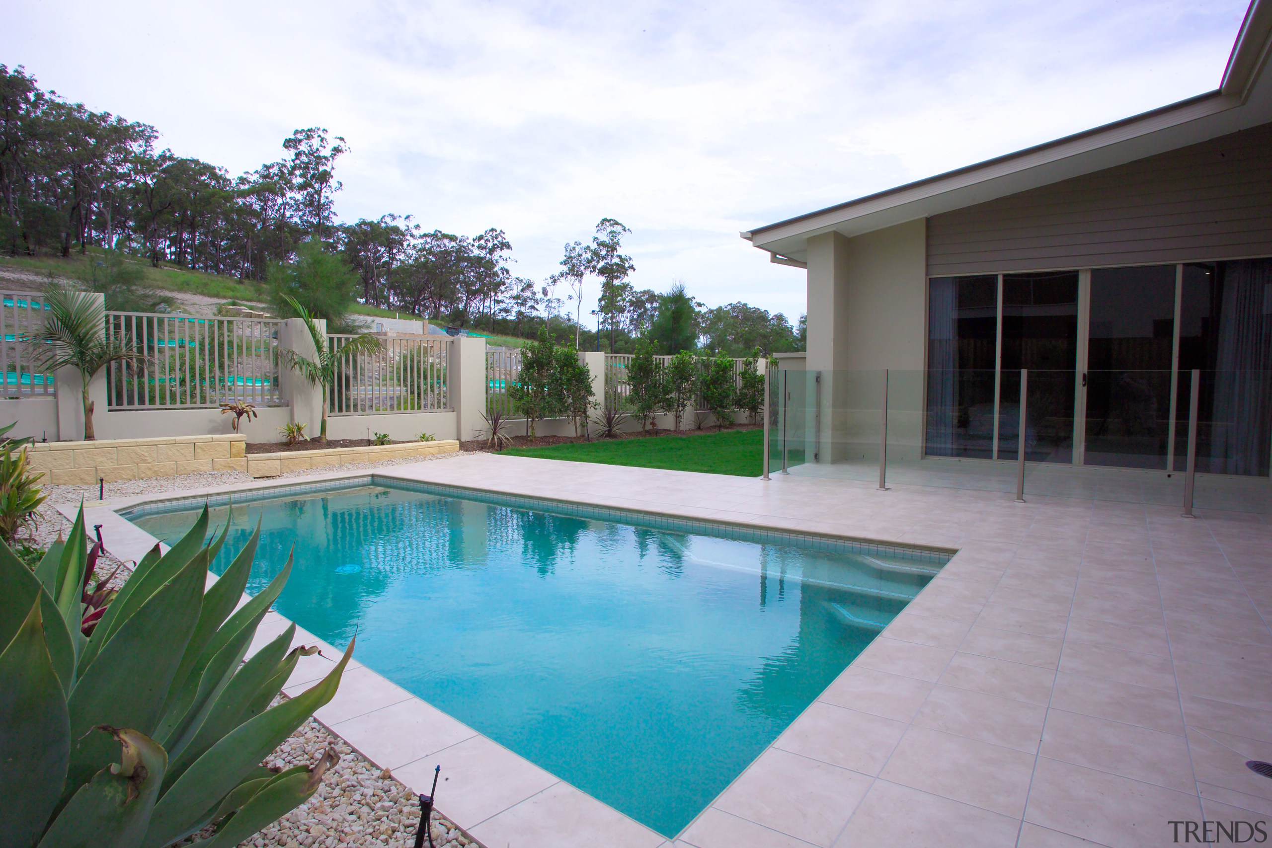 Exterior view of the rear of a home backyard, estate, home, house, leisure, outdoor structure, property, real estate, residential area, resort, swimming pool, villa, yard, white, gray