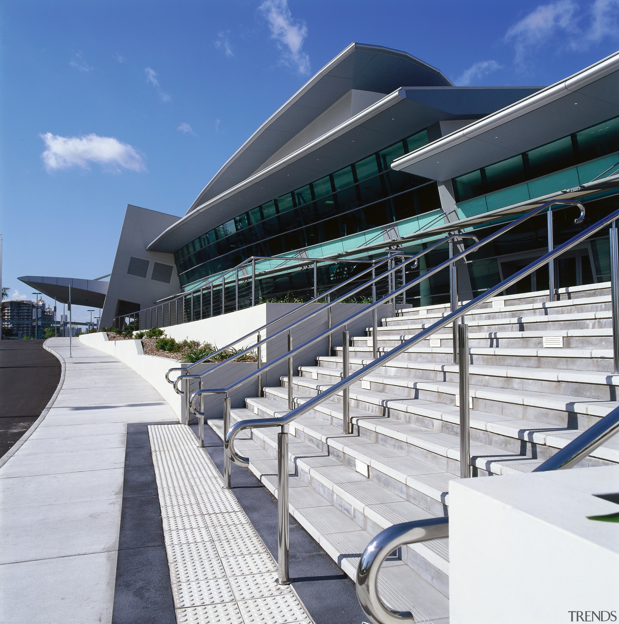 Concrete steps with stainless steel balustrades leading to architecture, building, convention center, corporate headquarters, facade, infrastructure, metropolitan area, sky, sport venue, structure, white, blue