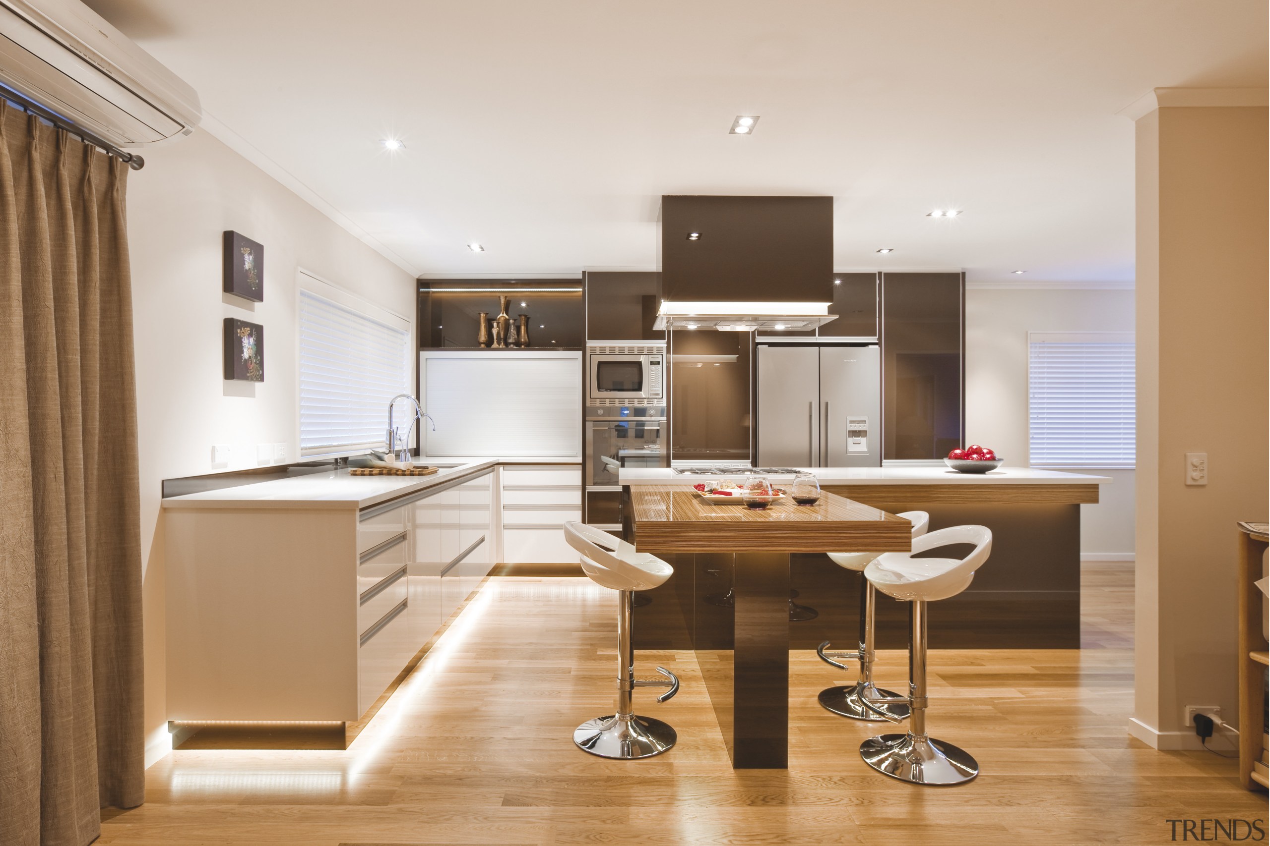 View of a kitchen which features island with cabinetry, countertop, cuisine classique, floor, furniture, interior design, kitchen, office, real estate, room, white, orange