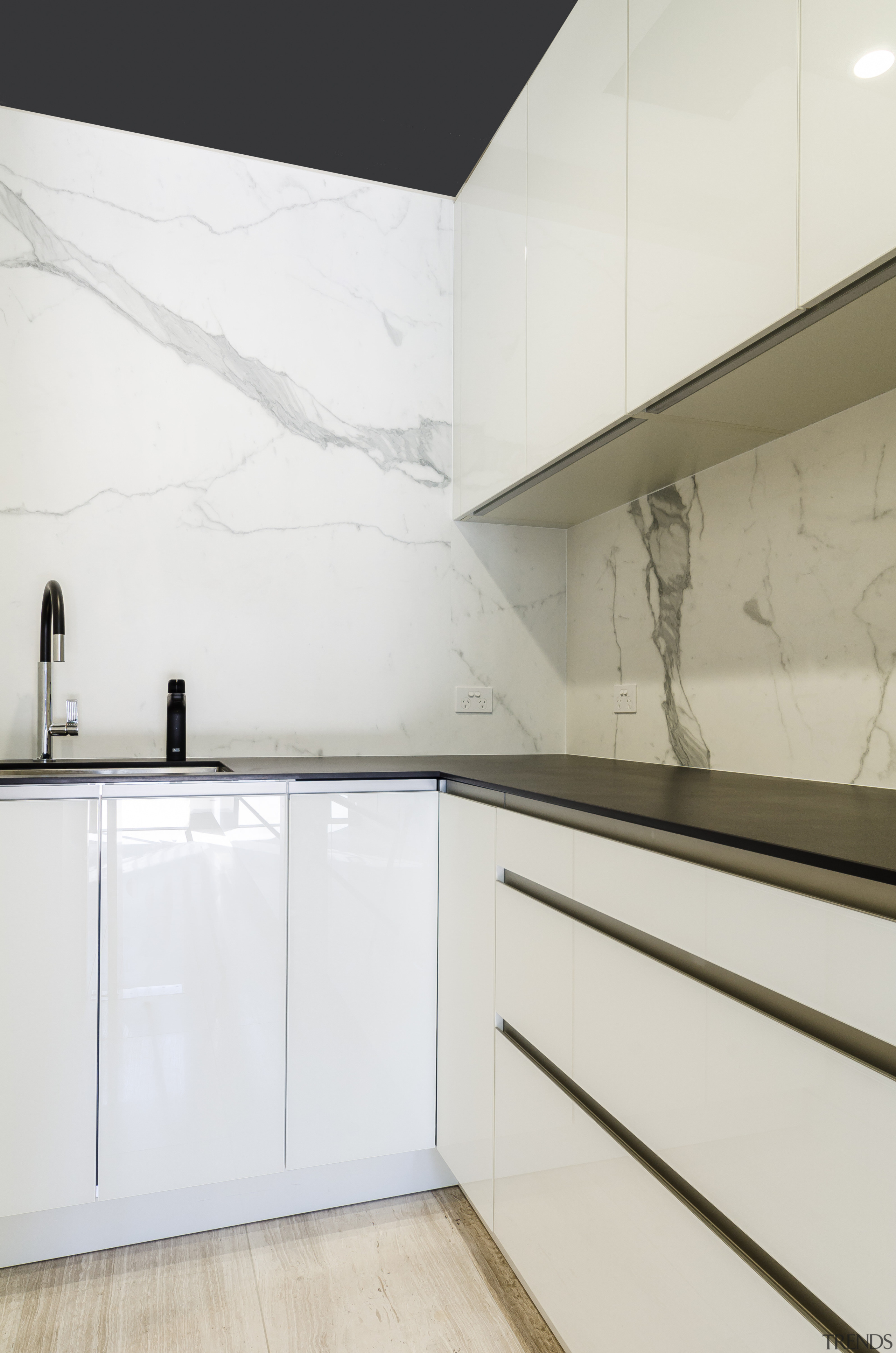 Sleek cabinet finishes seen in the kitchen are architecture, countertop, floor, interior design, kitchen, product design, property, tap, wall, white
