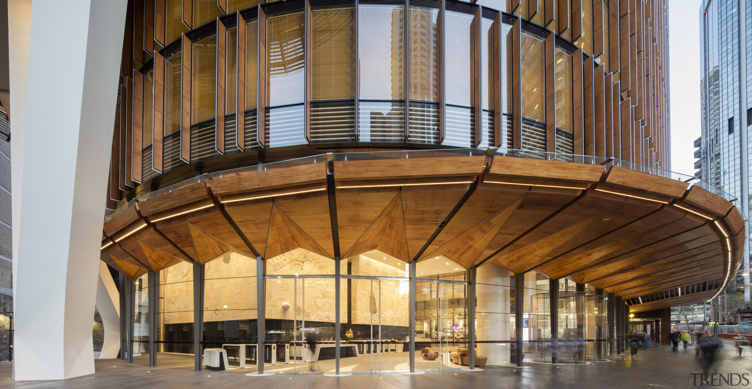 Broad folded timber awnings shade the street at architecture, building, ceiling, daylighting, lobby, brown