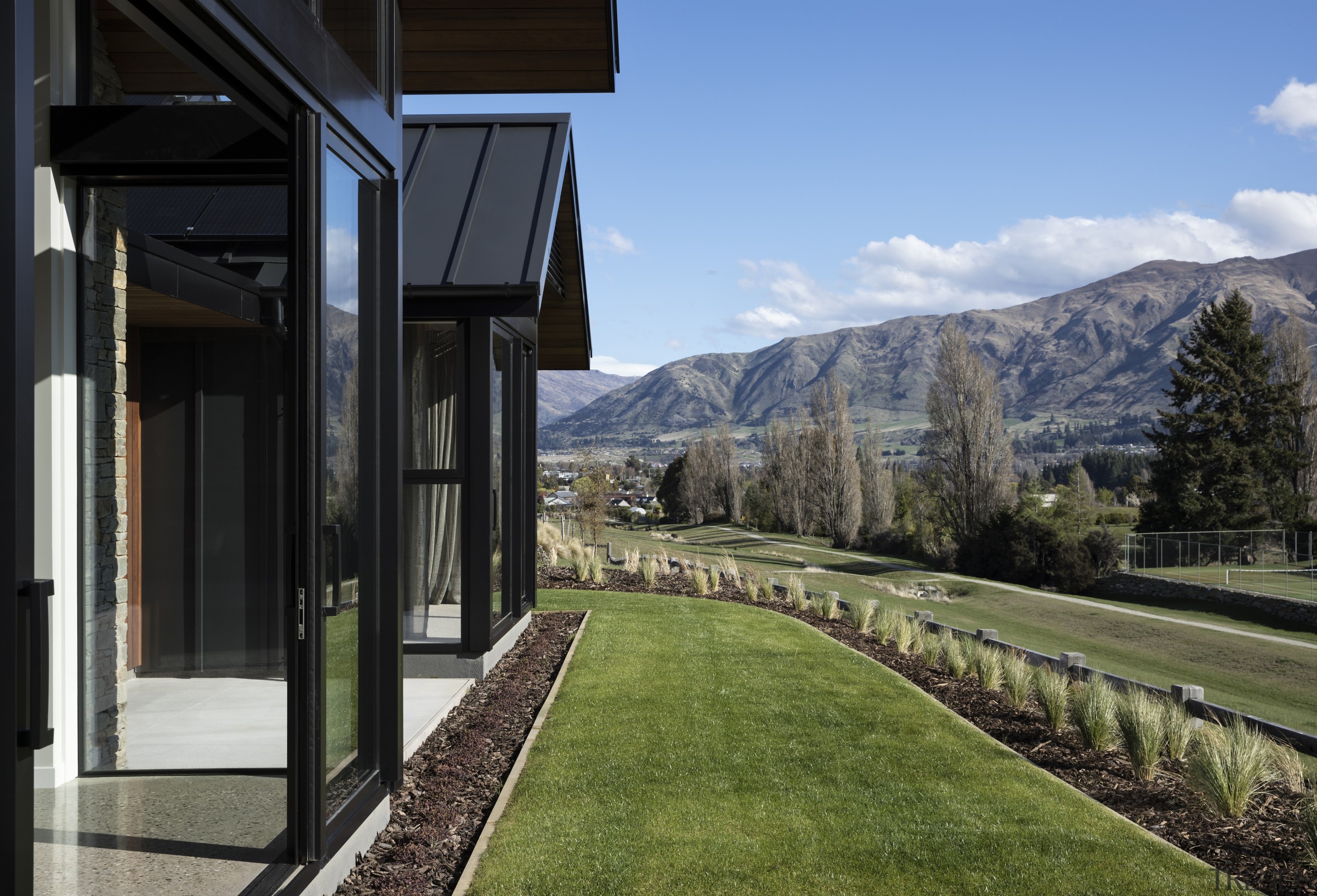 ​​​​​​​On this home by Condon Scott Architects, the alps, architecture, home, house, landscape, landscaping, lawn, mountain, mountain range, Condon Scott Architects