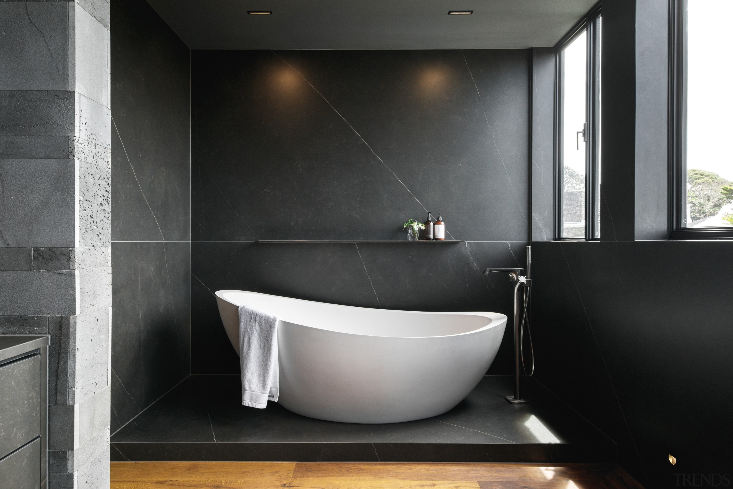 The freestanding bath sits on a pedestal floor 