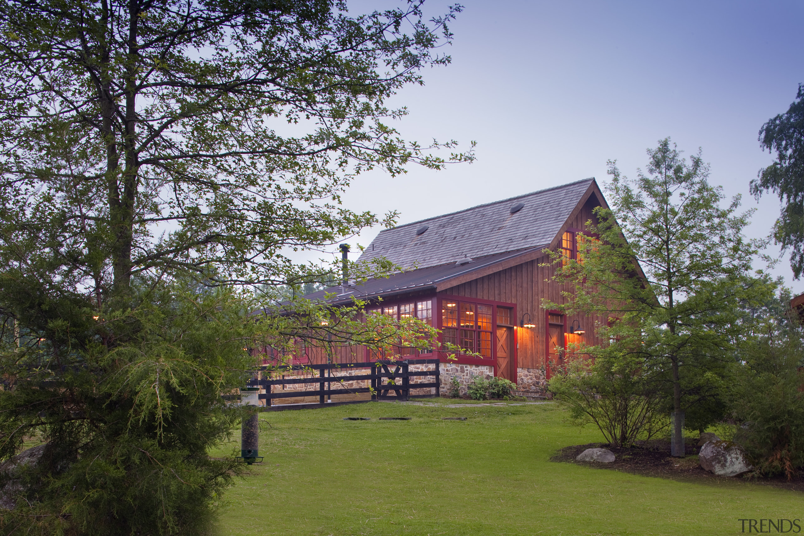 View of wooden home with lawn in foreground. architecture, barn, cottage, estate, farmhouse, grass, home, house, landscape, log cabin, nature, plant, real estate, rural area, sky, tree, brown