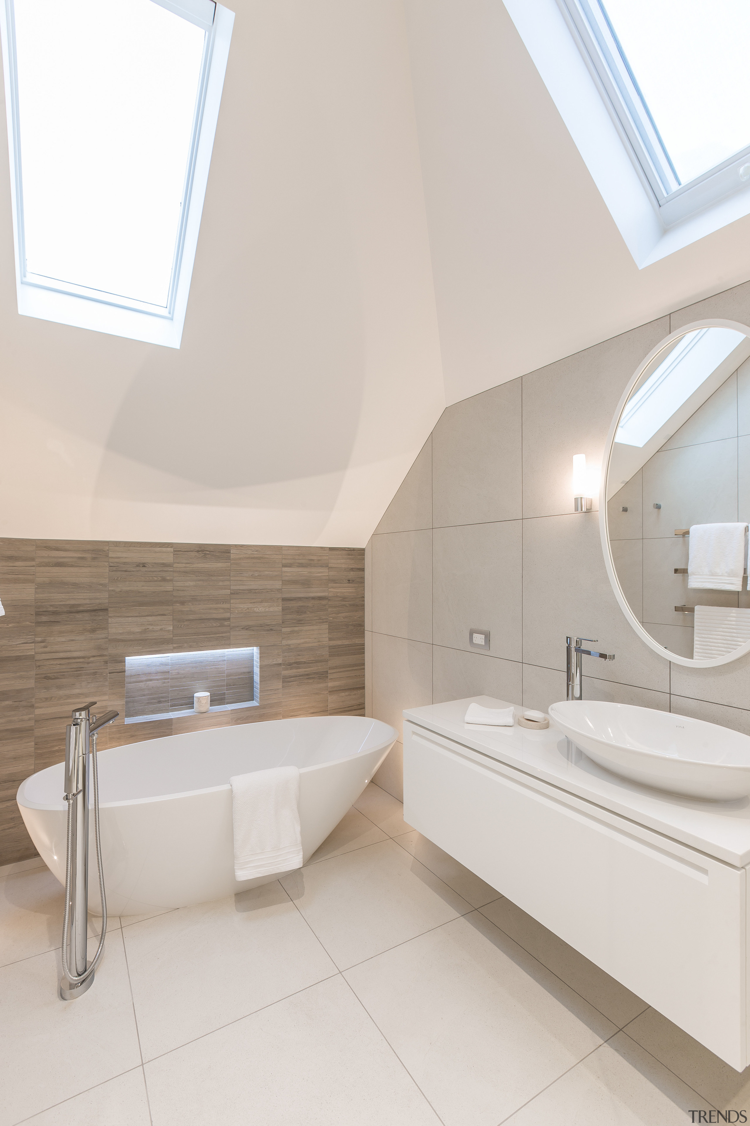 An angular, asymmetrical ceiling is echoed in the architecture, bathroom, bathroom sink, daylighting, floor, home, interior design, plumbing fixture, product design, room, sink, tap, tile, white