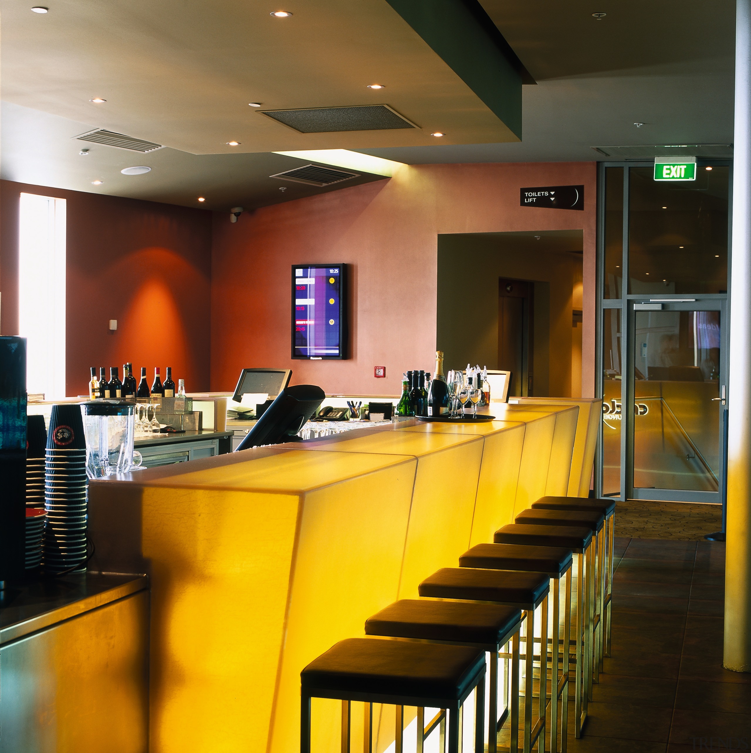 Bar area of cinema complex with yellow bar interior design, lighting, restaurant, table, brown