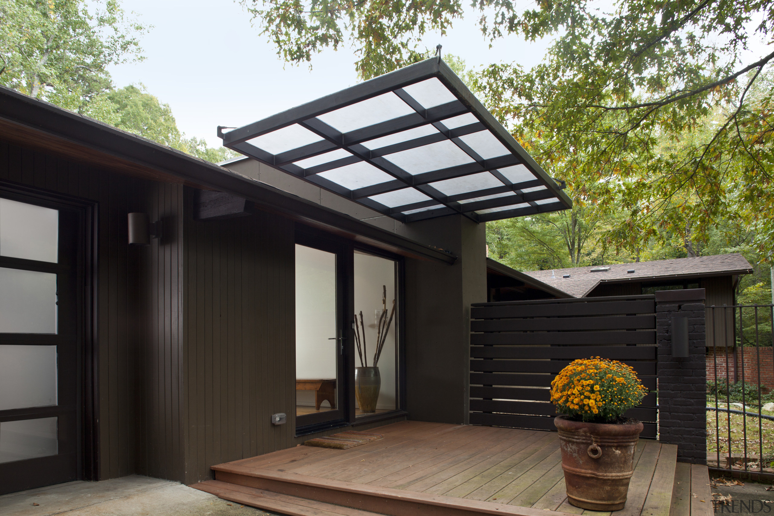 This prefabricated post-and-beam house has been transformed by backyard, house, outdoor structure, roof, black